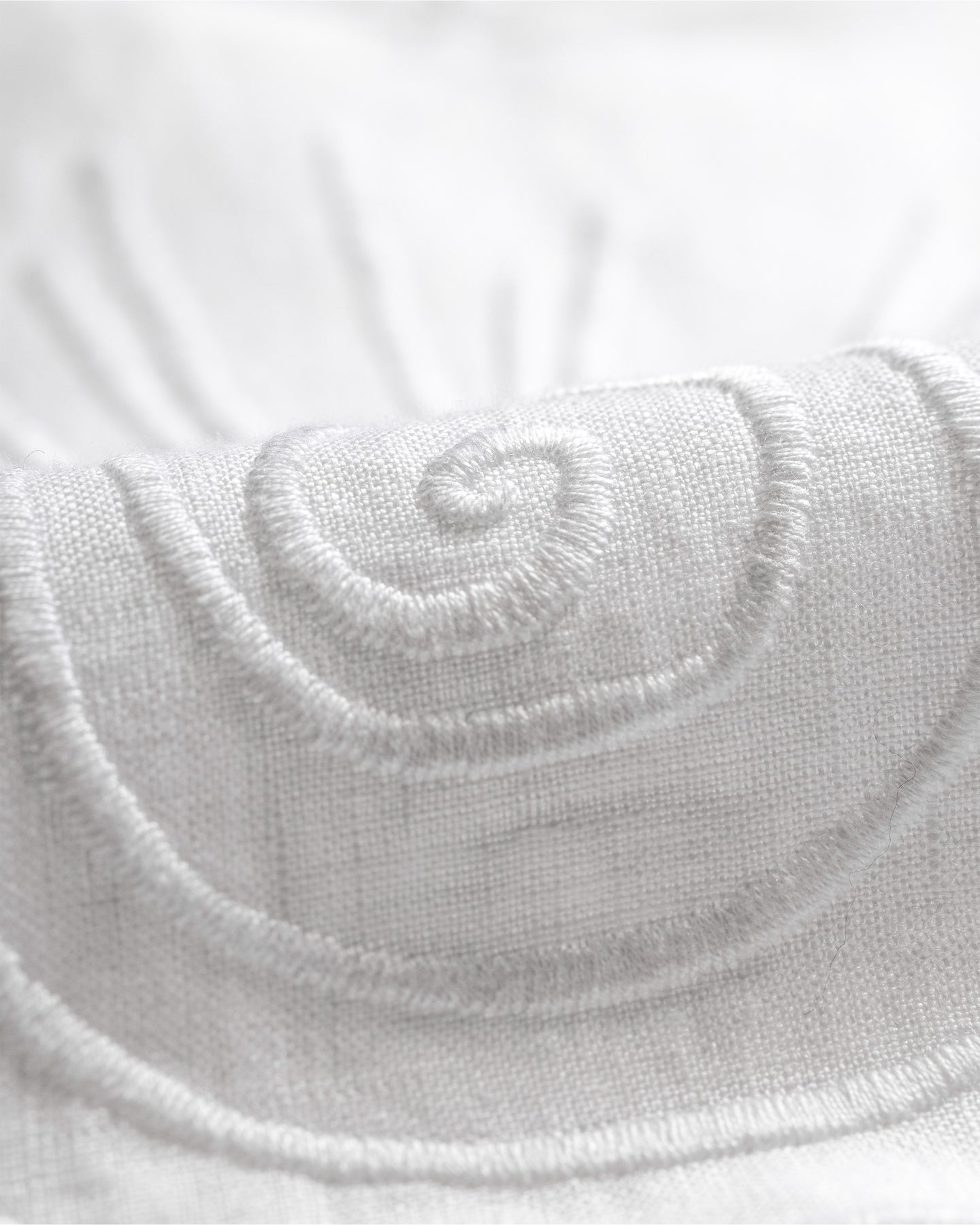 Close-up of a white textured fabric with a brand logo.