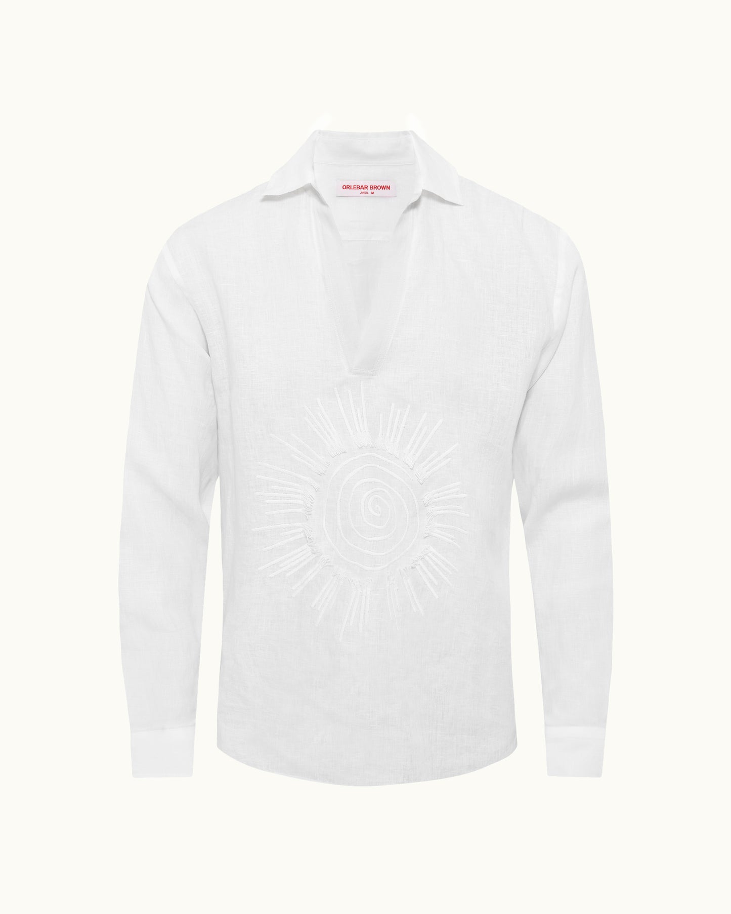 White shirt with sun embroidery on a plain background