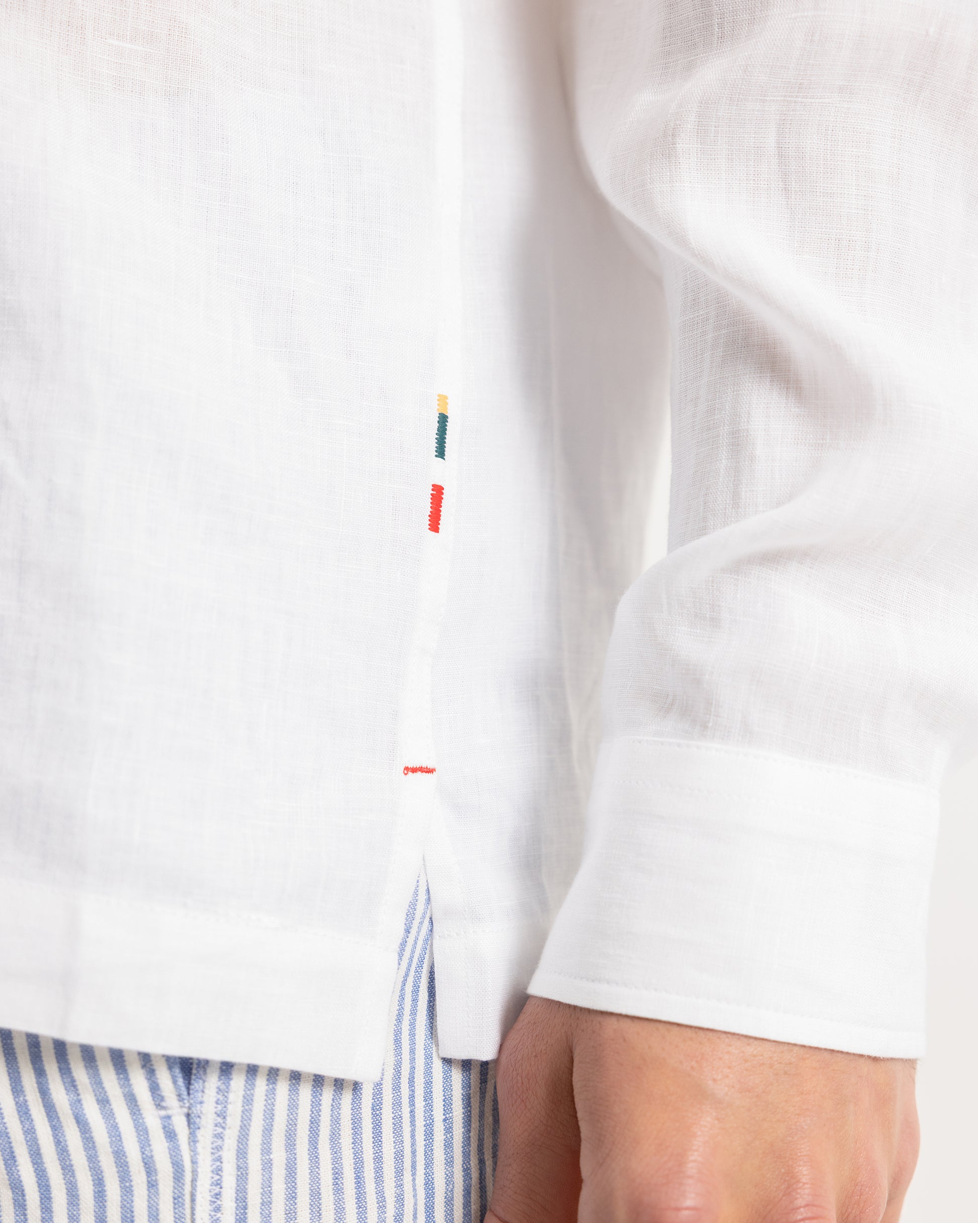 Close-up of a white shirt with colorful buttons on a white background