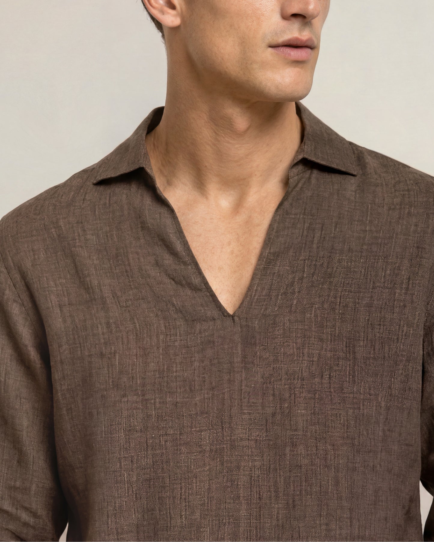 Man wearing a brown textured shirt against a neutral background
