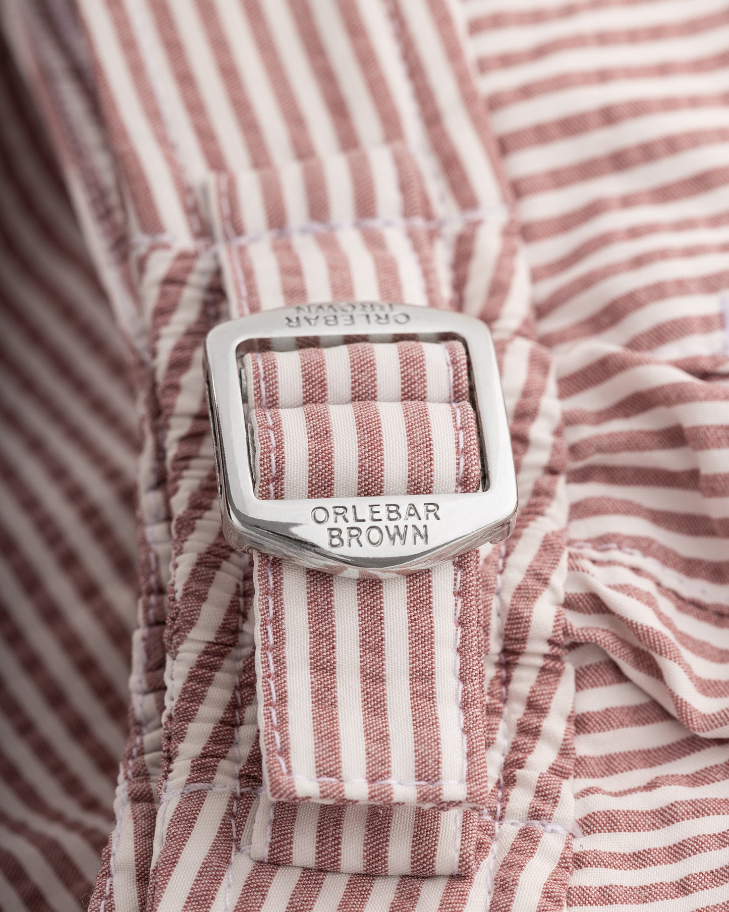 Close-up of a red and white striped shirt with a visible brand label.