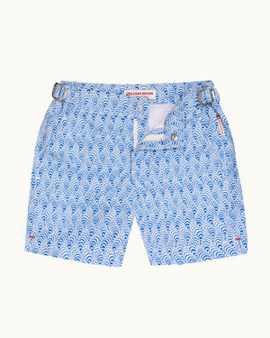 Blue and white patterned shorts with a wave print, featuring a zippered front pocket and a red brand label at the waistband, shown flat on a light background.