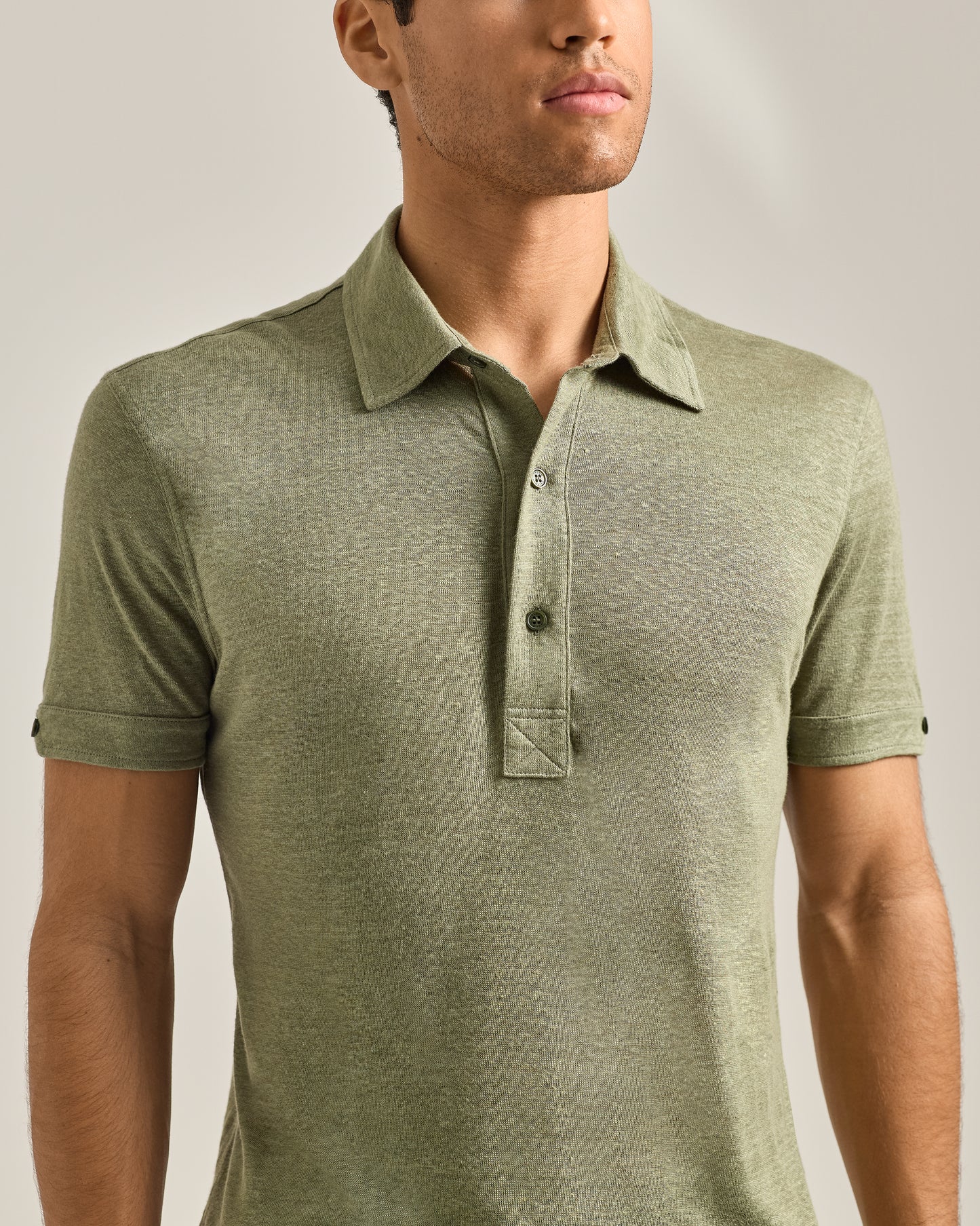 Man wearing a green polo shirt against a neutral background