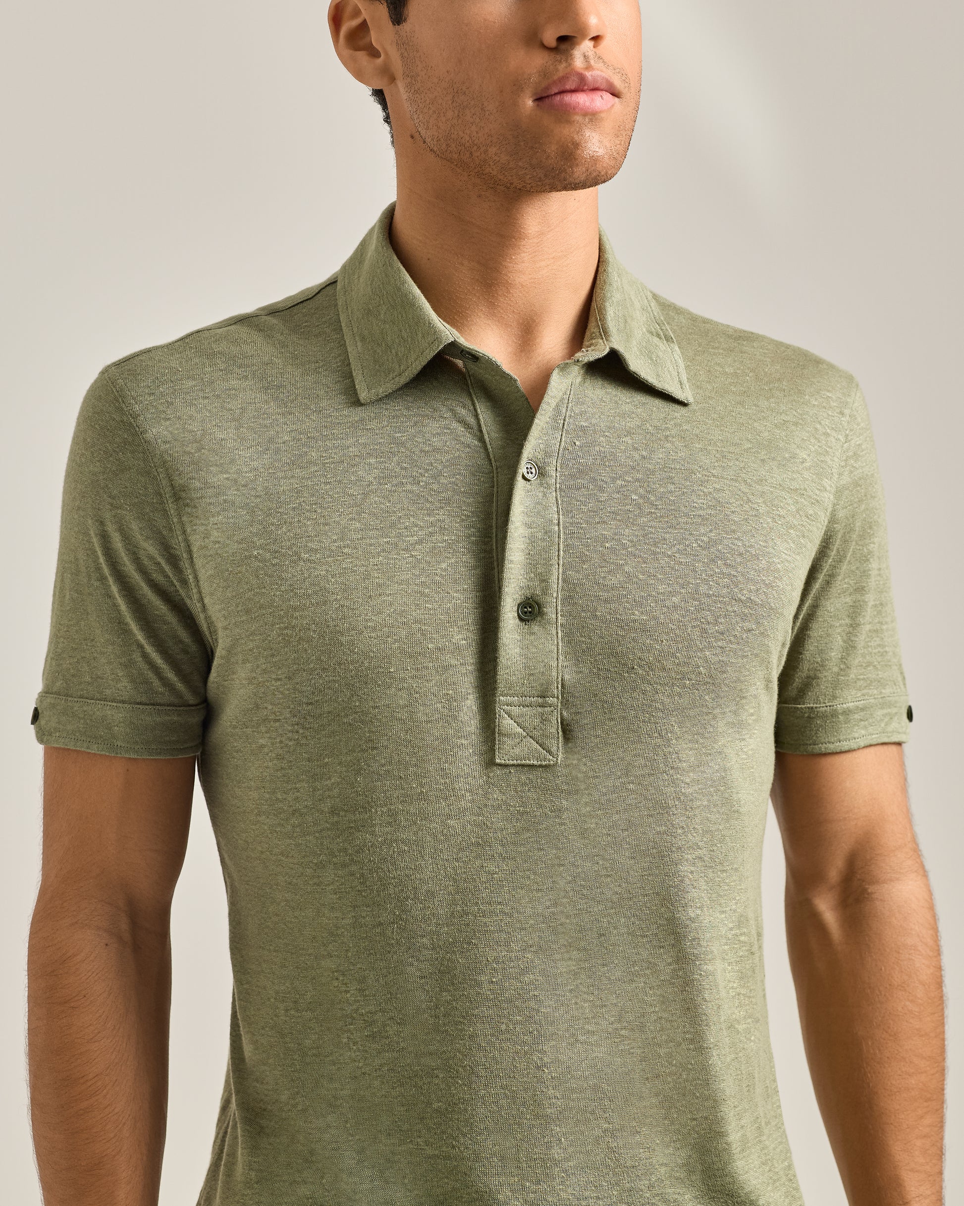 Man wearing a green polo shirt against a neutral background
