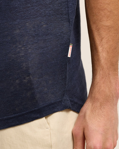 Closeup of navy linen polo shirt with Orlebar Brown logo tag on seam