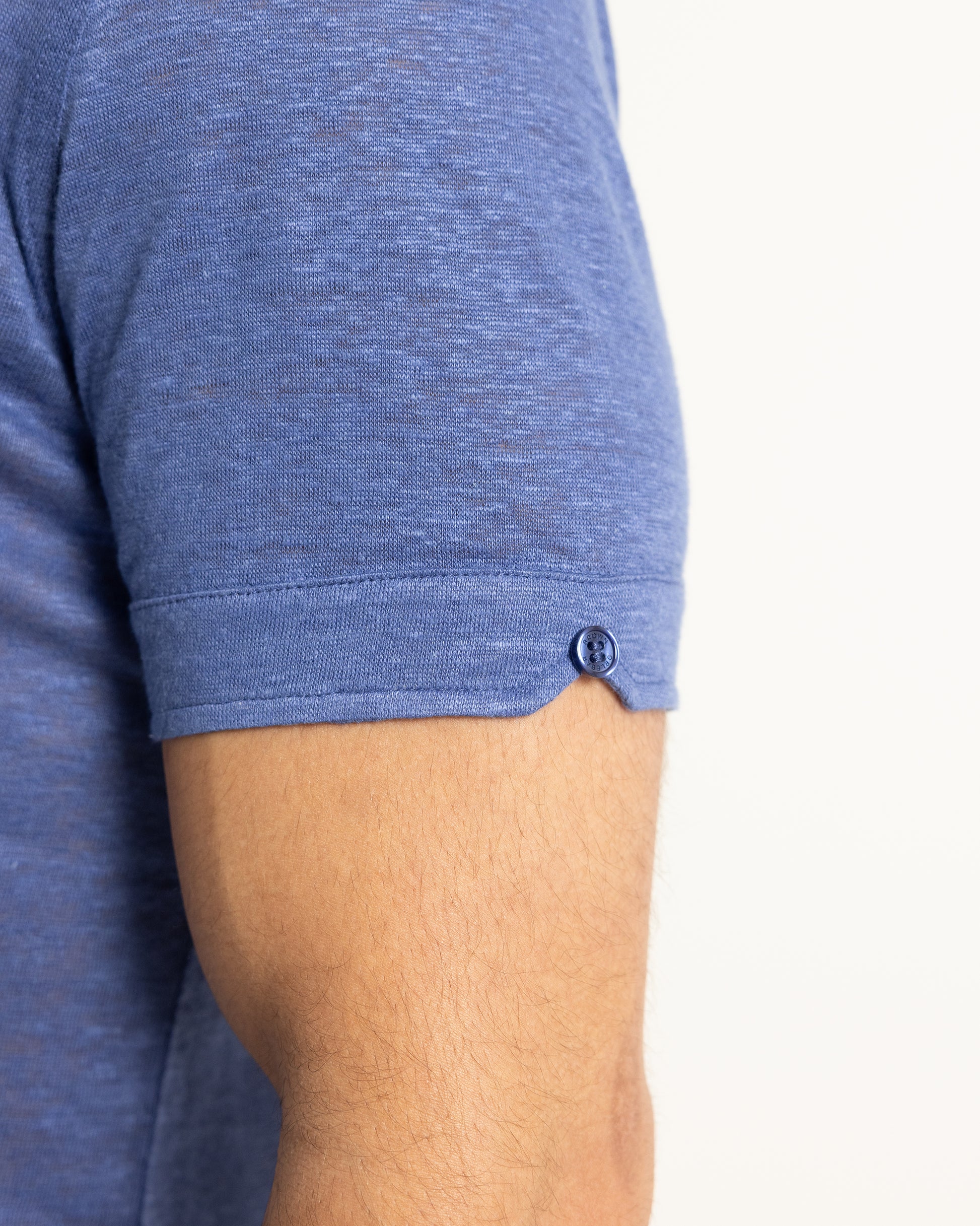 Close-up of a person wearing a blue shirt with a button on a white background