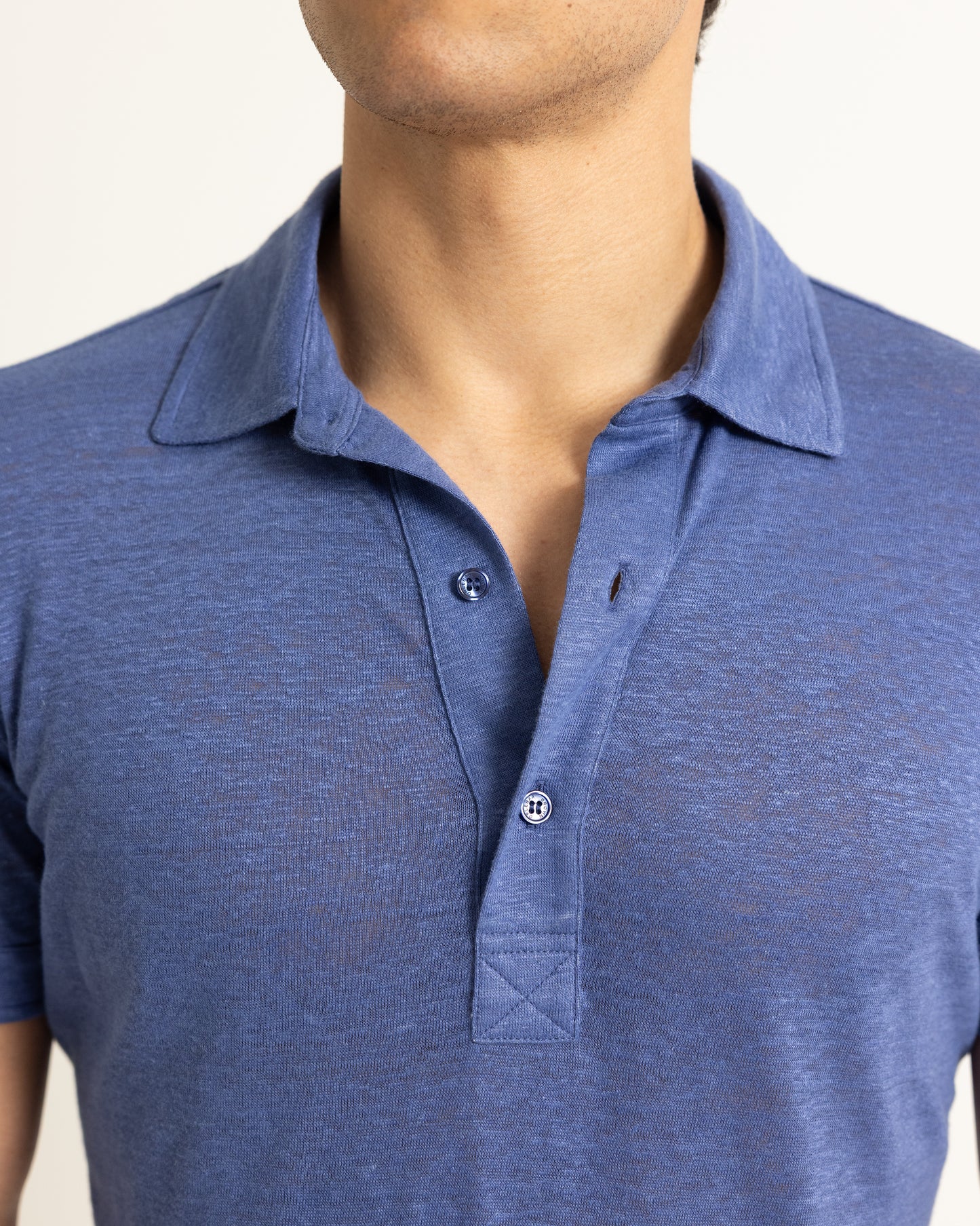 Blue polo shirt worn by a person on a plain background