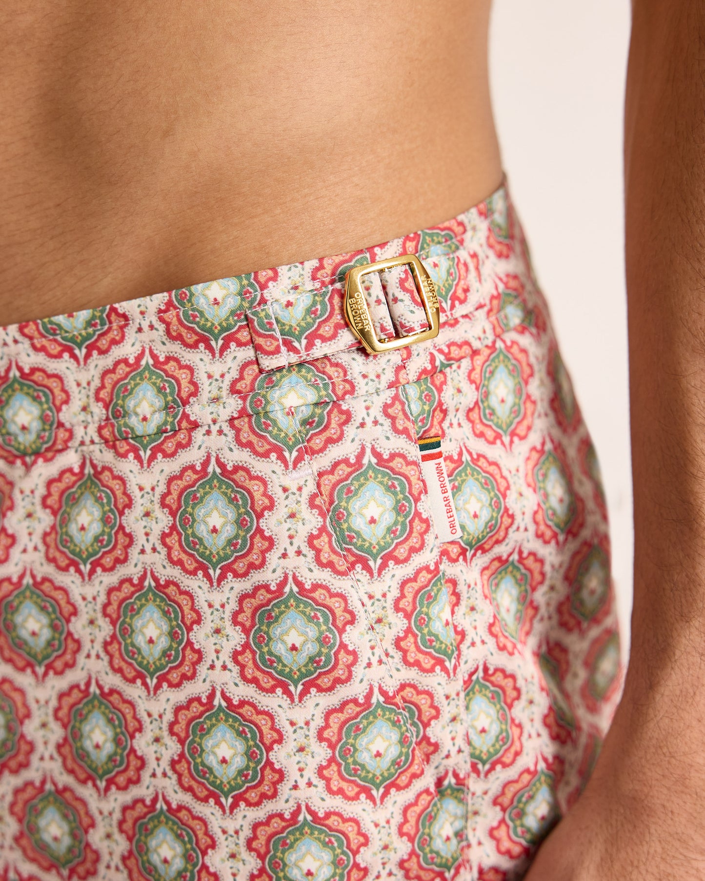 Close-up of a person wearing a patterned garment with a visible brand logo.