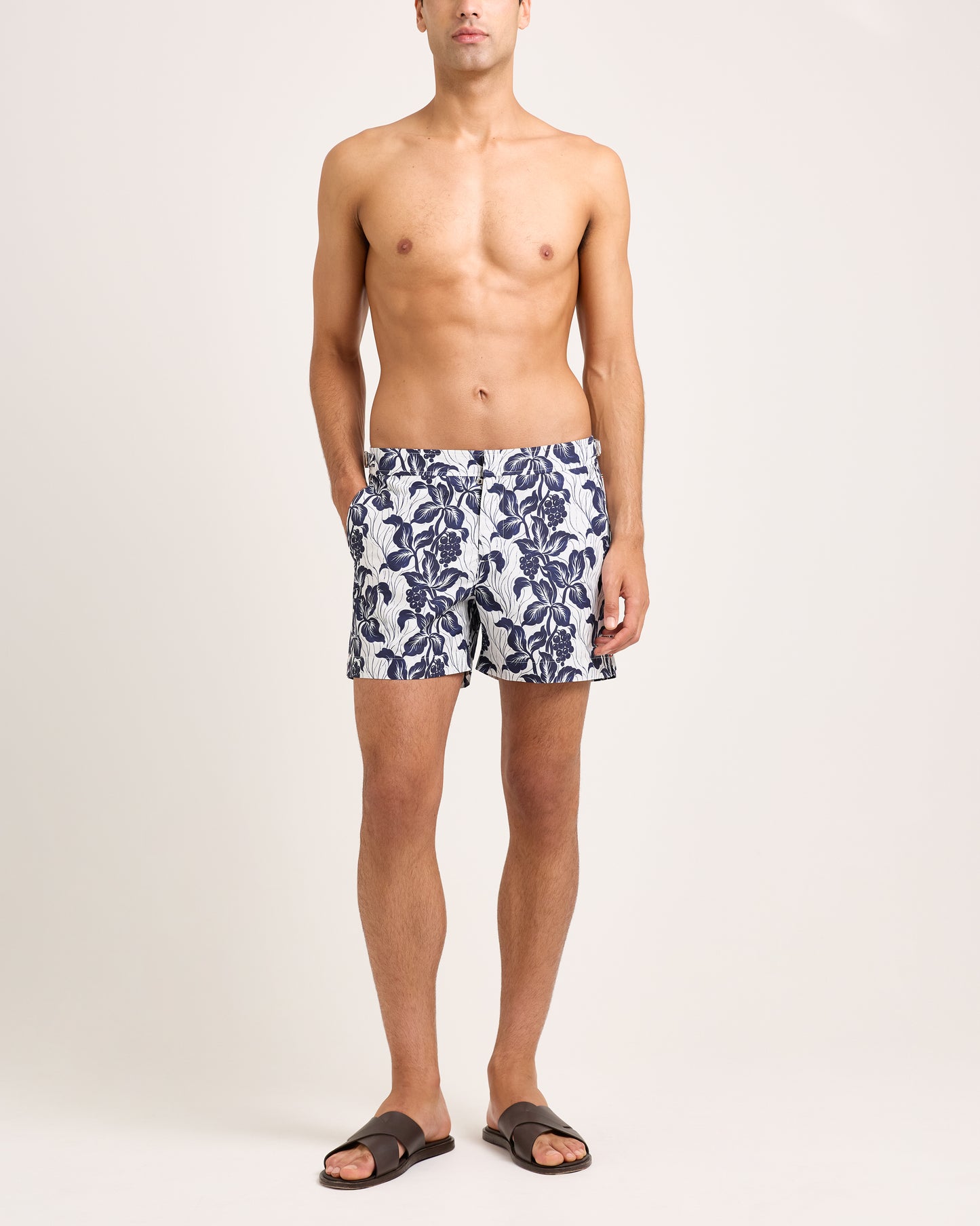 Model wearing floral navy swim shorts on a white background