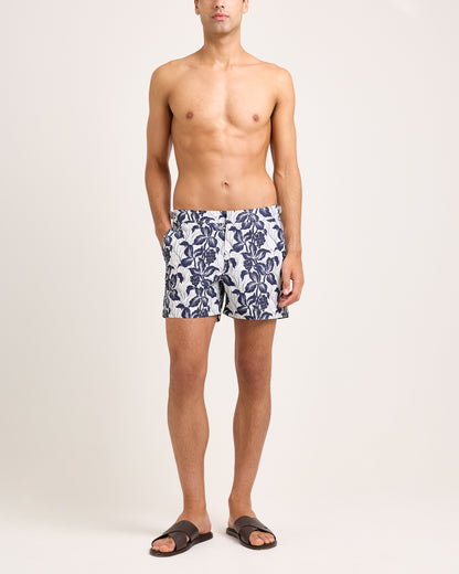 Model wearing floral navy swim shorts on a white background