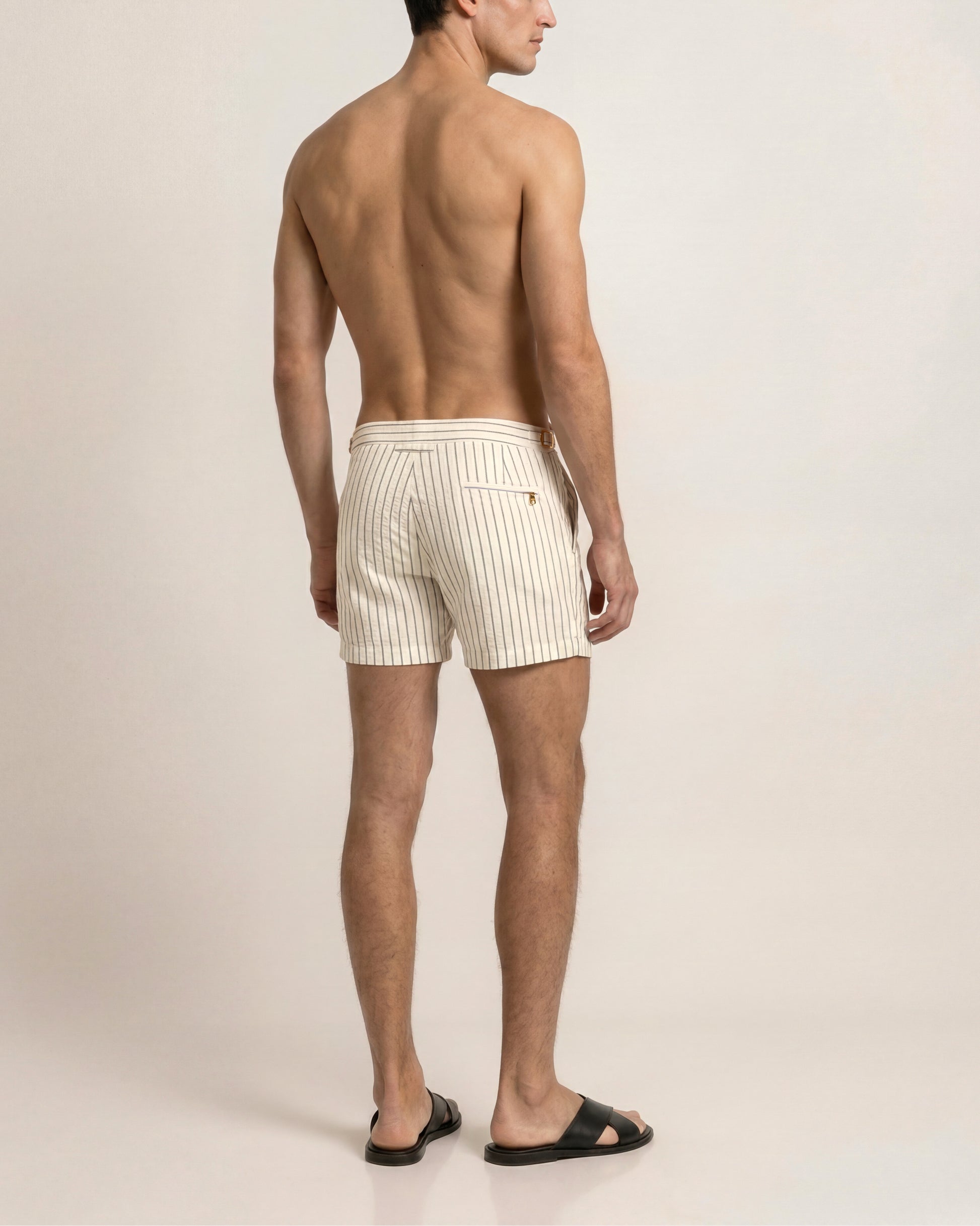 Man wearing white striped boxer shorts on a plain background