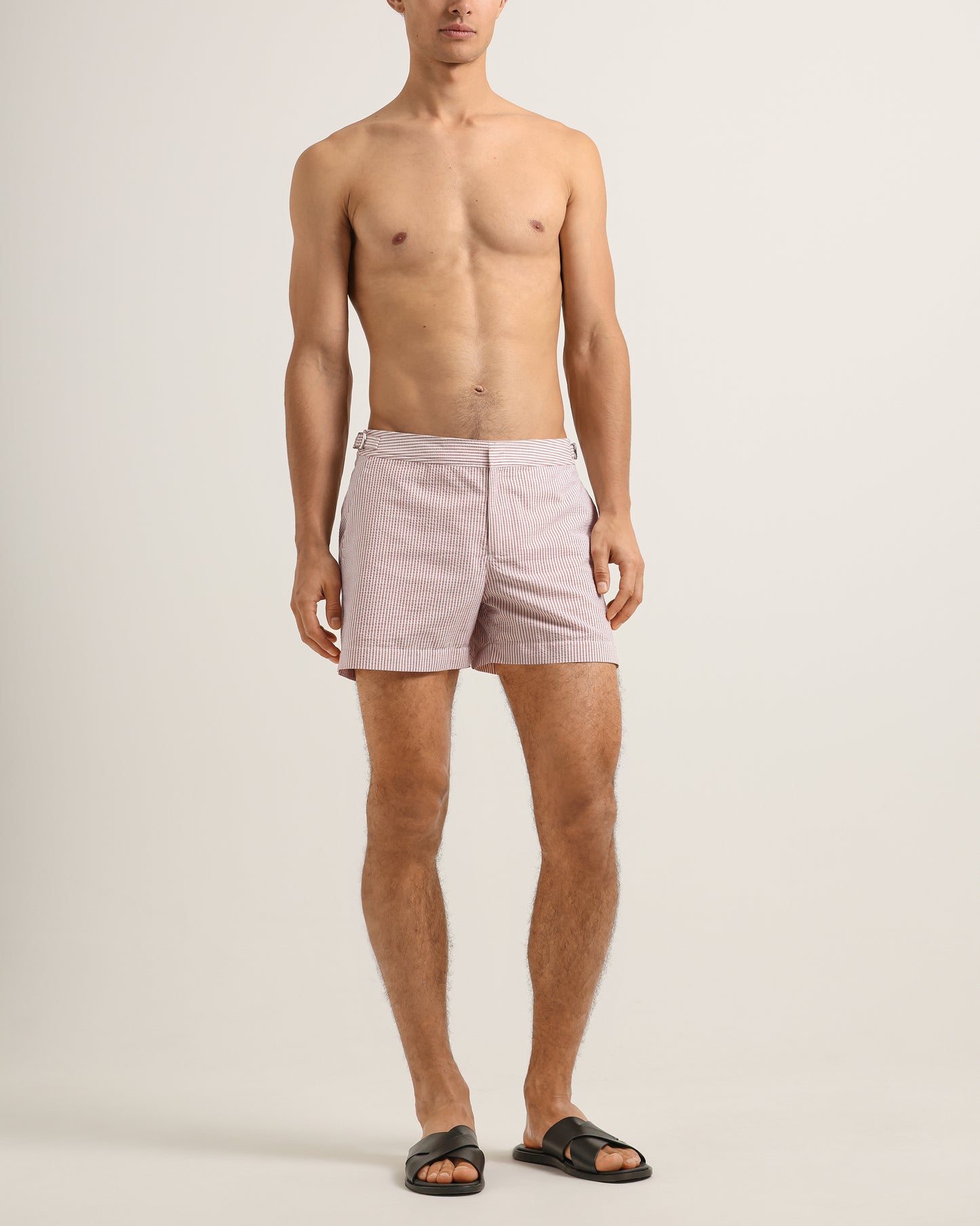 Man wearing light purple shorts on a plain background