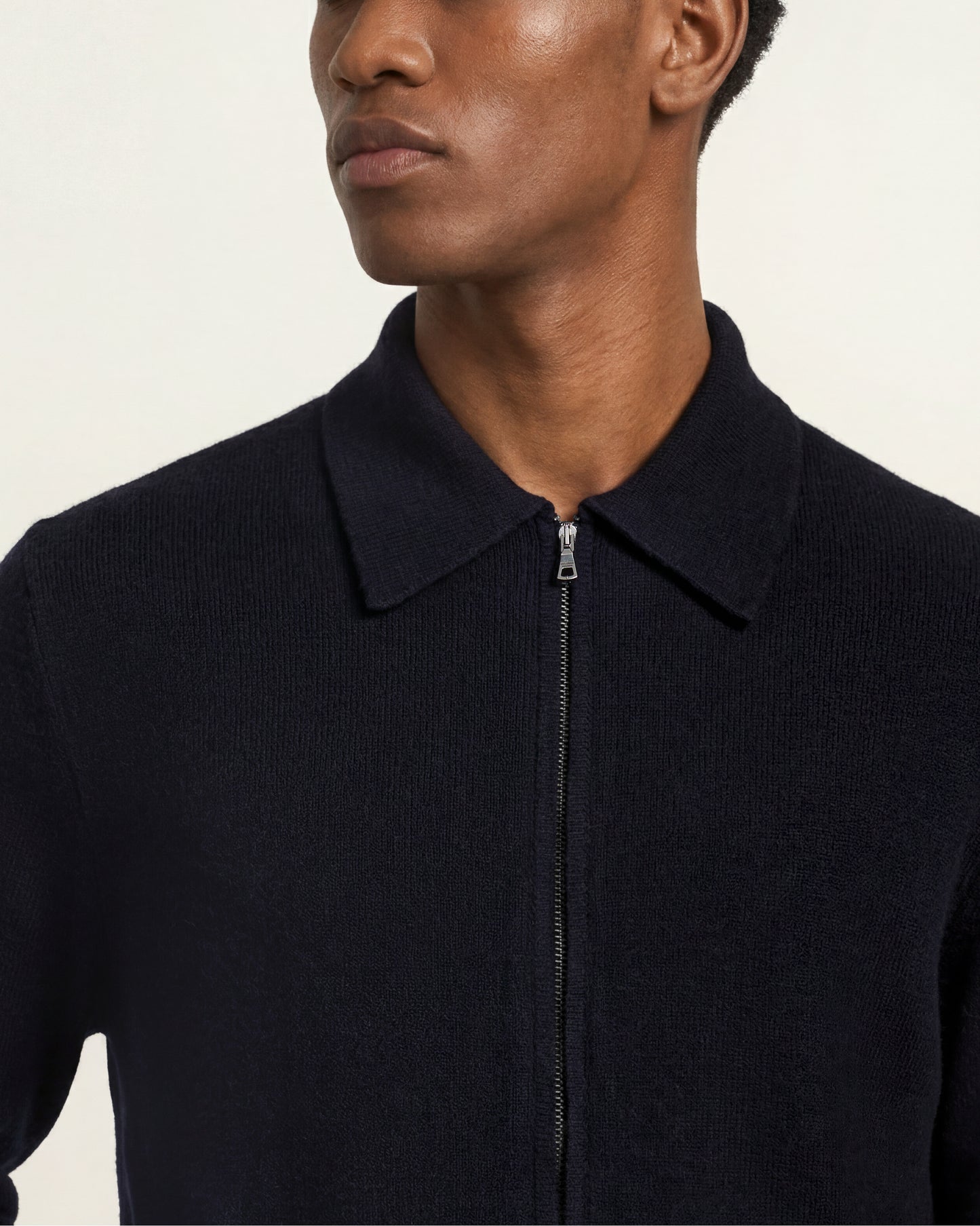 Close up of zipper and collar of the navy knitted zip up sweater