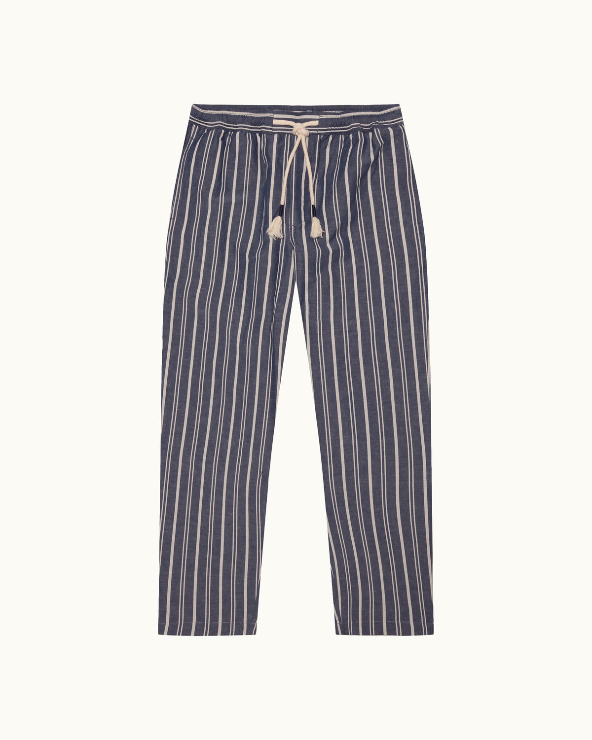 A pair of navy blue and off-white vertically striped pants with an elastic waistband and a cream-colored drawstring, against a light cream background.