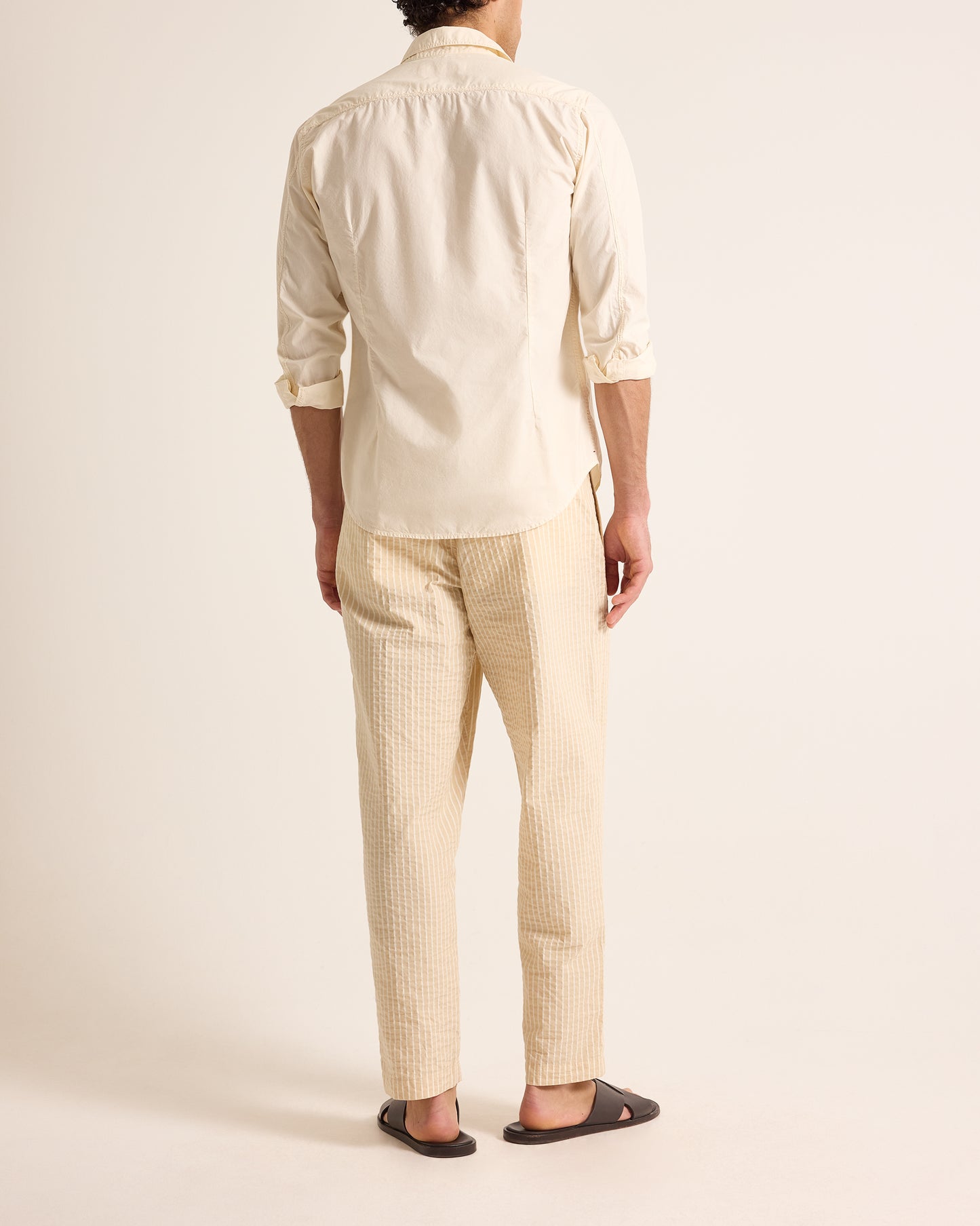 Man wearing light beige shirt and trousers with drawstring waist on a light background