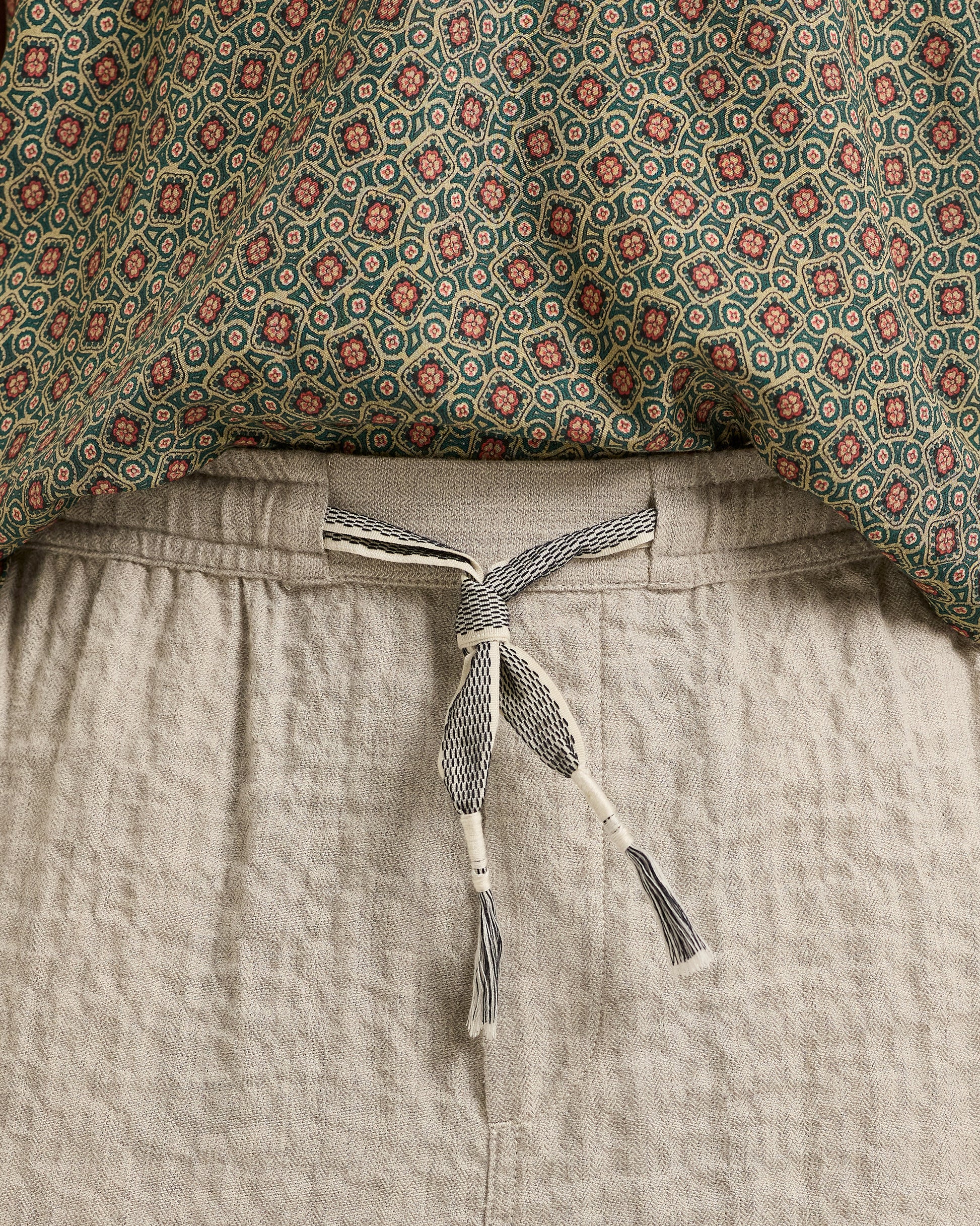 Patterned fabric and beige pants with a tie detail