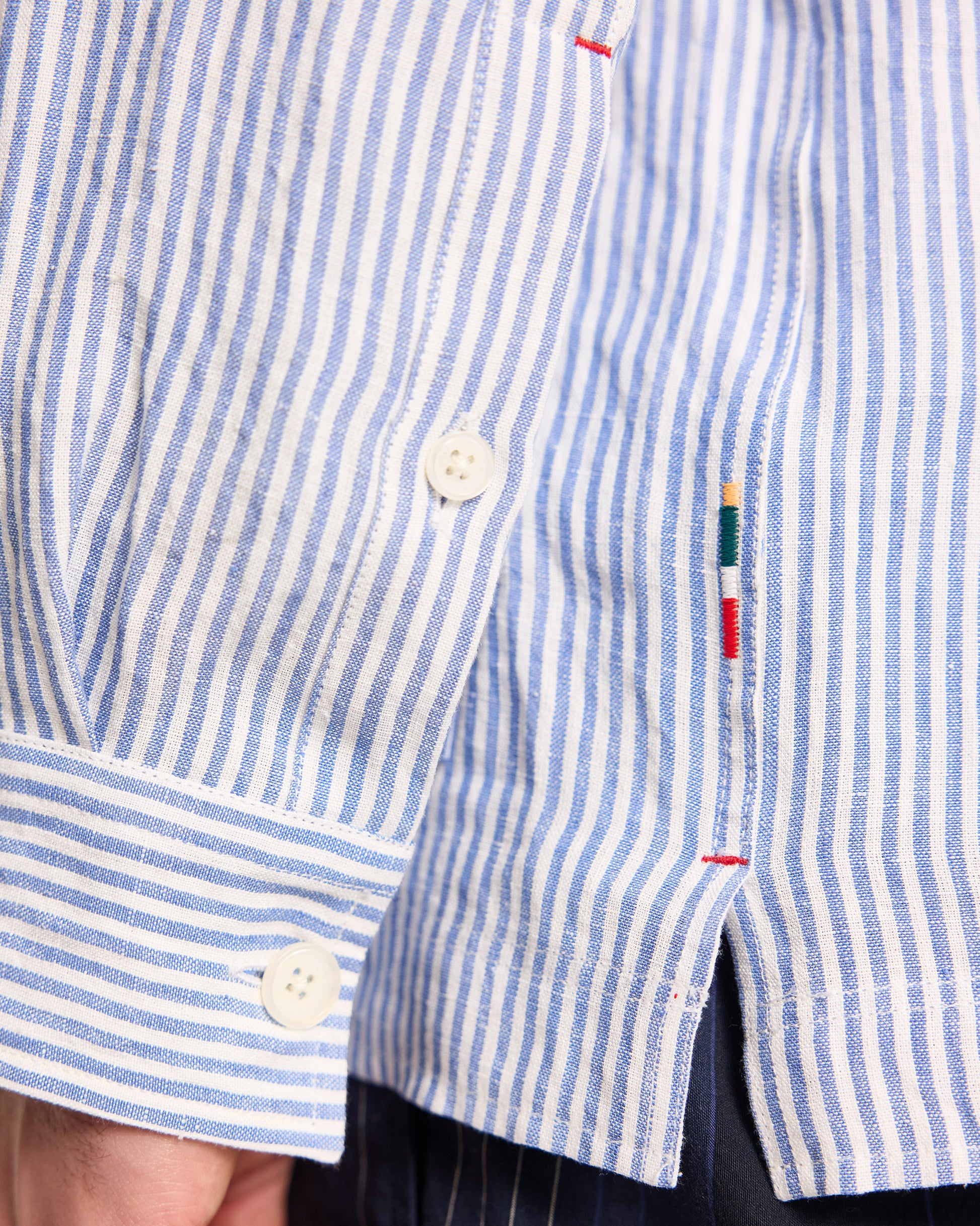 Close-up of a blue and white striped shirt with a small flag emblem on the sleeve.