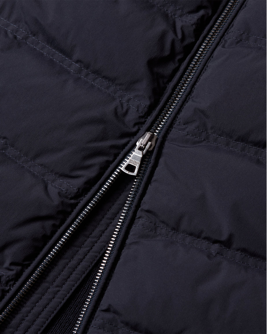 Close-up of a black quilted puffer jacket with a silver metal zipper.