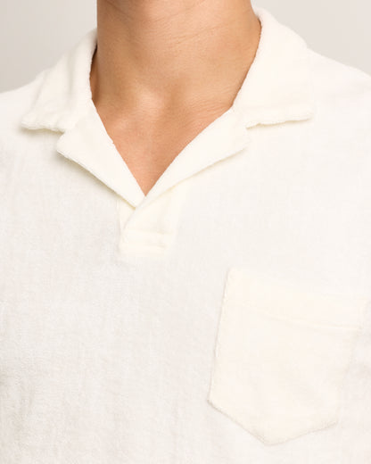 Close-up of a person wearing a white towelling polo shirt with a collar.