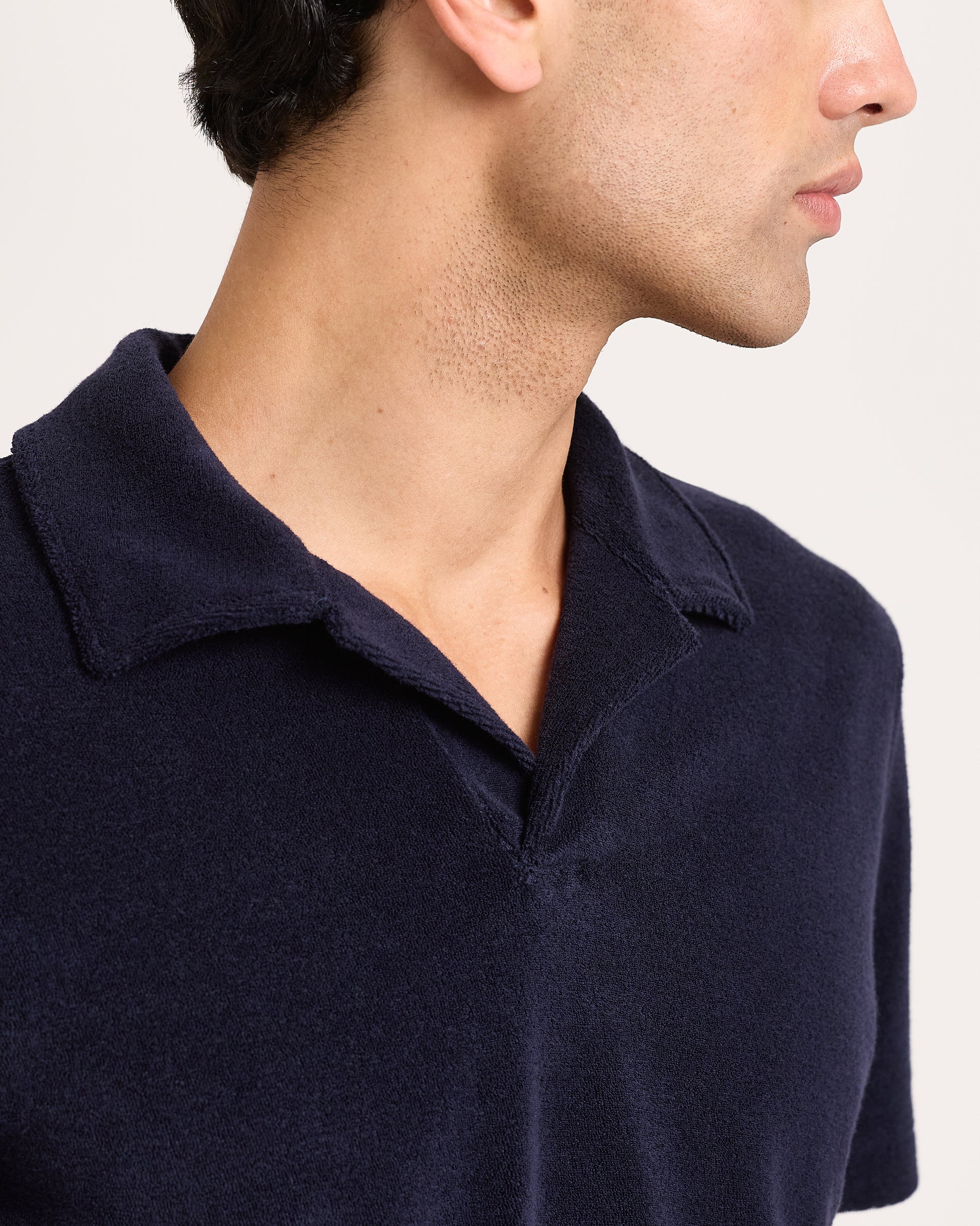 Navy blue polo shirt worn by a person on a white background