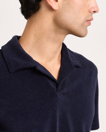 Navy blue polo shirt worn by a person on a white background