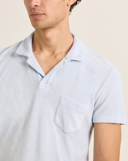 Light blue short-sleeve shirt worn by a person on a beige background