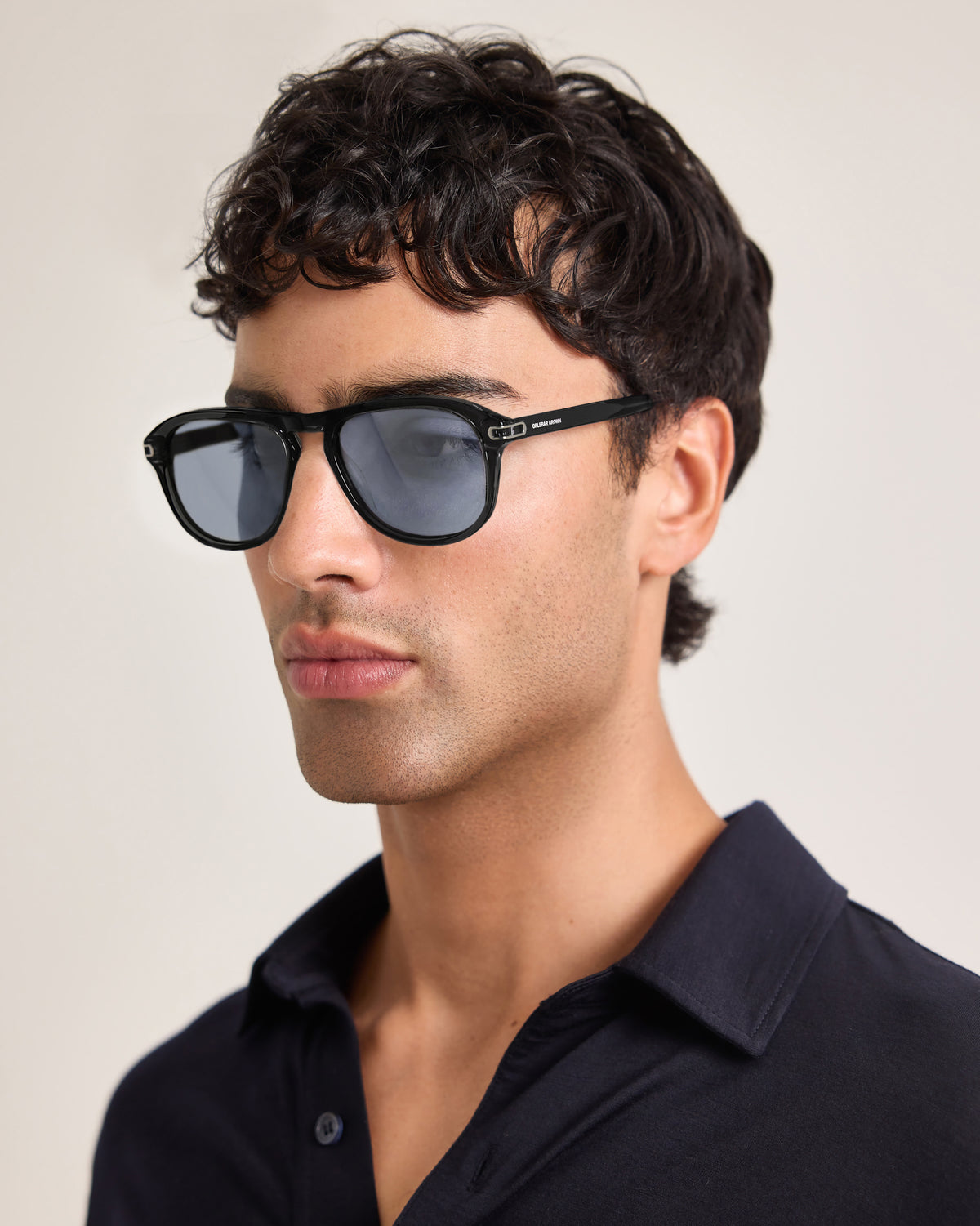 Man wearing black sunglasses with a neutral background