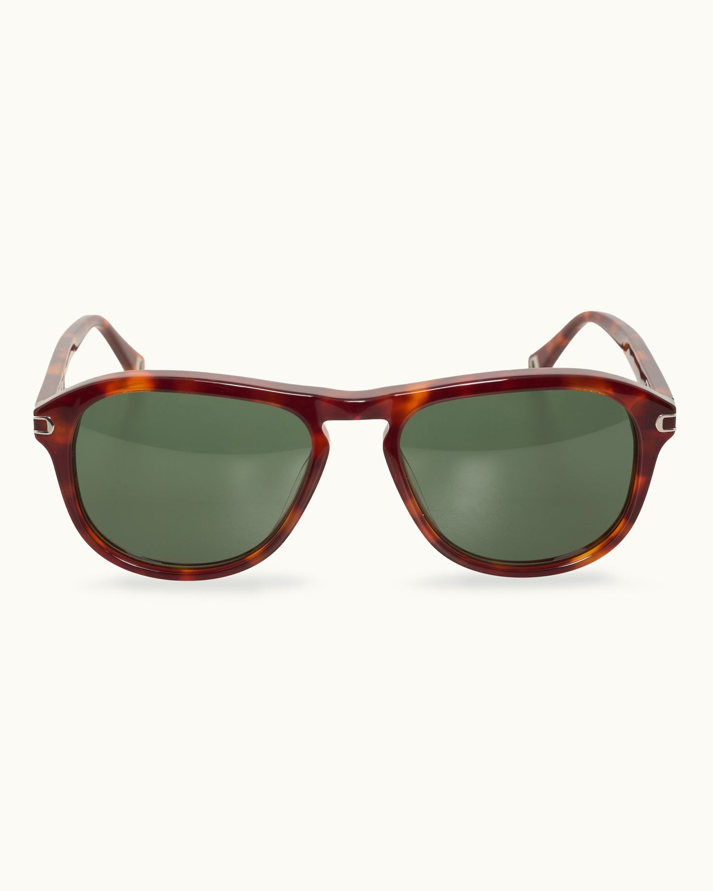 Sunglasses with tortoiseshell frame and green lenses on a white background