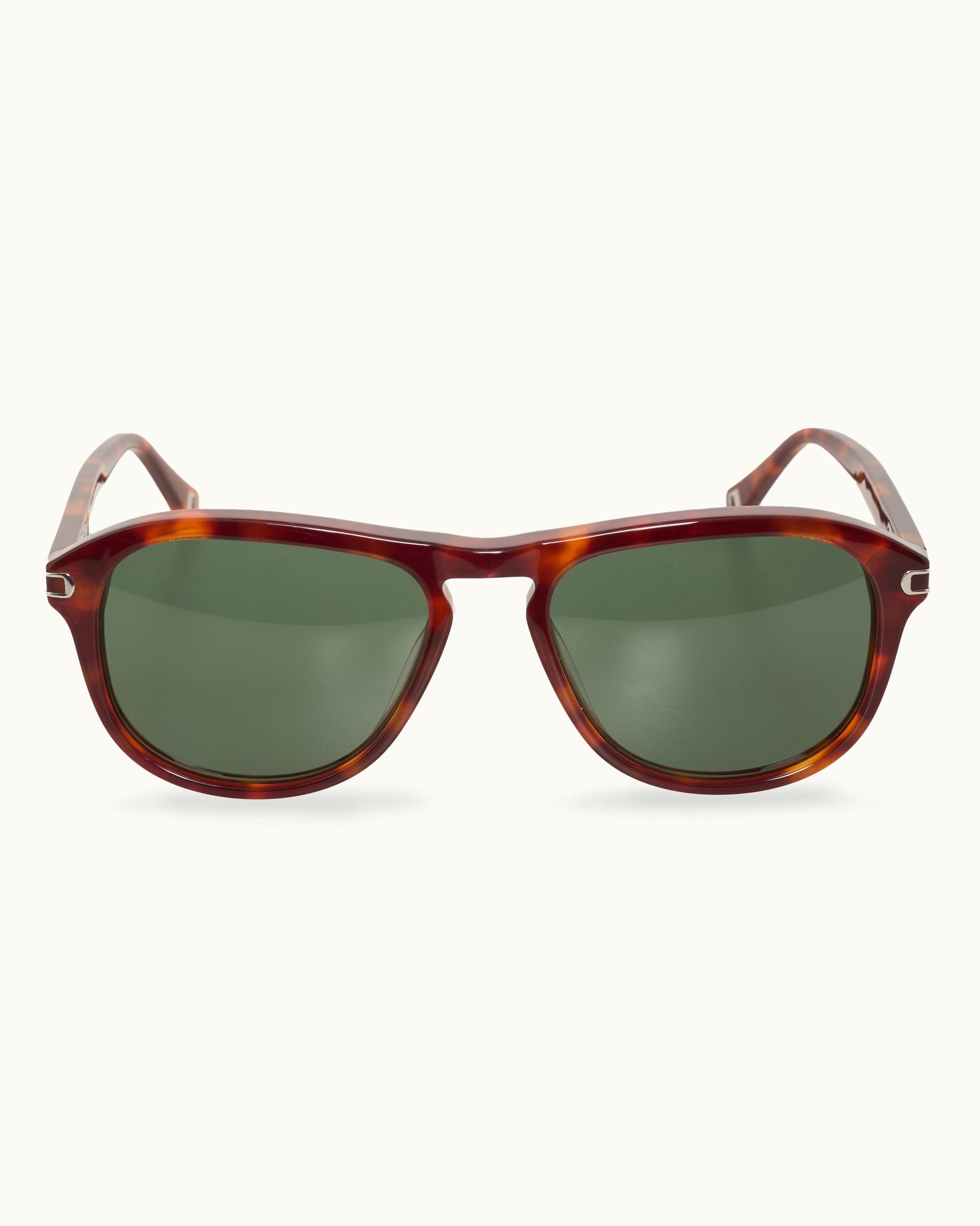 Sunglasses with tortoiseshell frame and green lenses on a white background