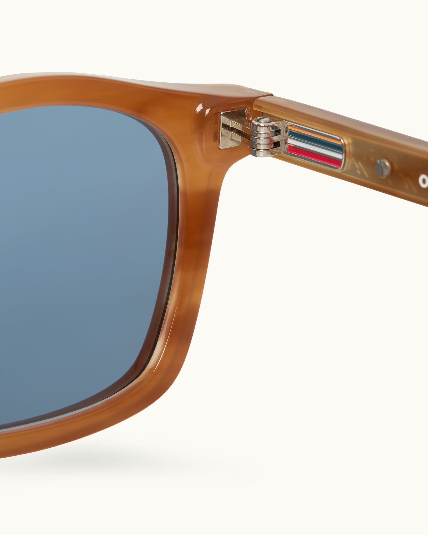 Close-up of a sunglasses with a brown frame and blue lens on a white background