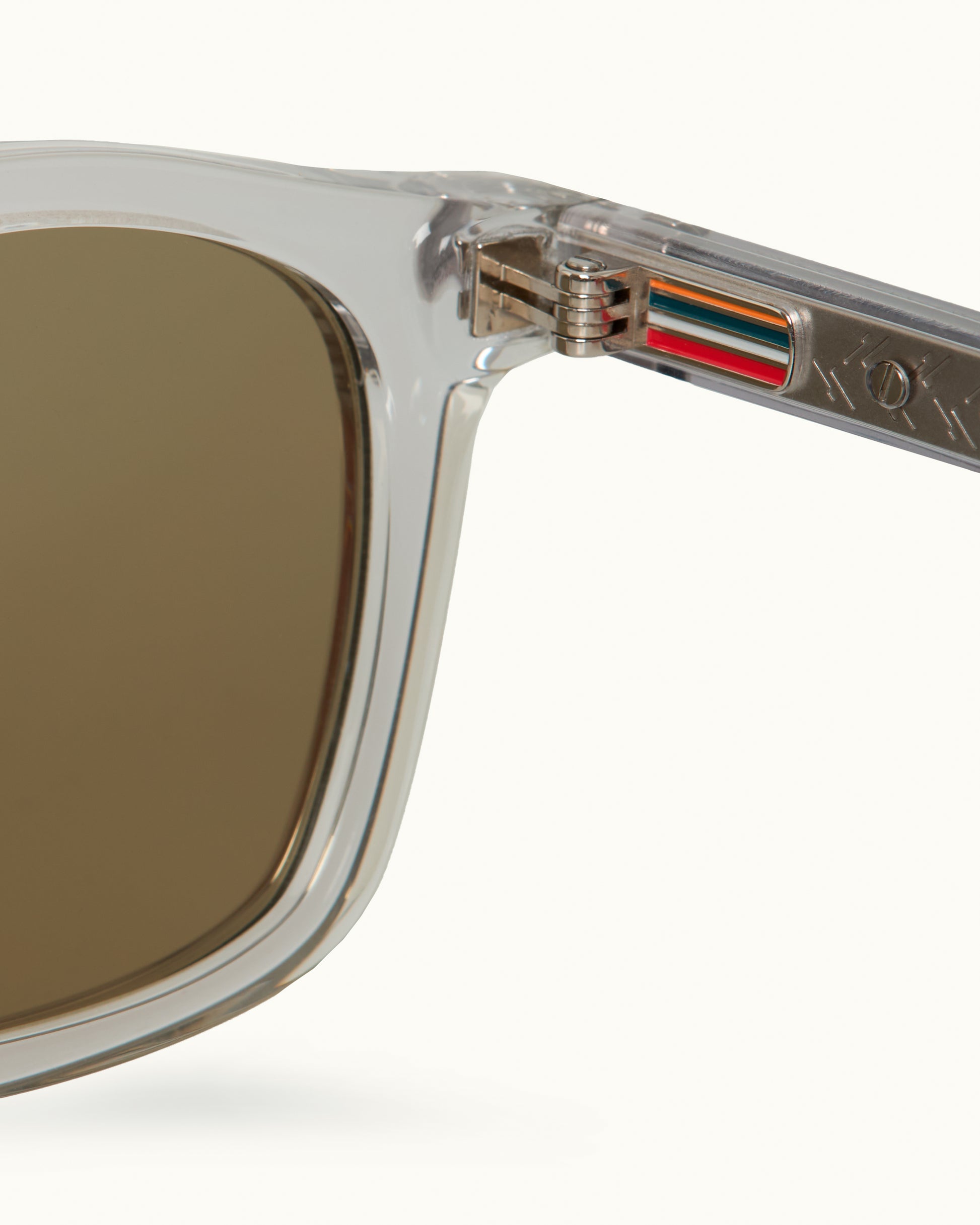 Close-up of a sunglasses with a clear frame and brown lens on a white background