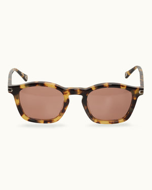 Sunglasses with tortoiseshell frame and brown lenses on a white background