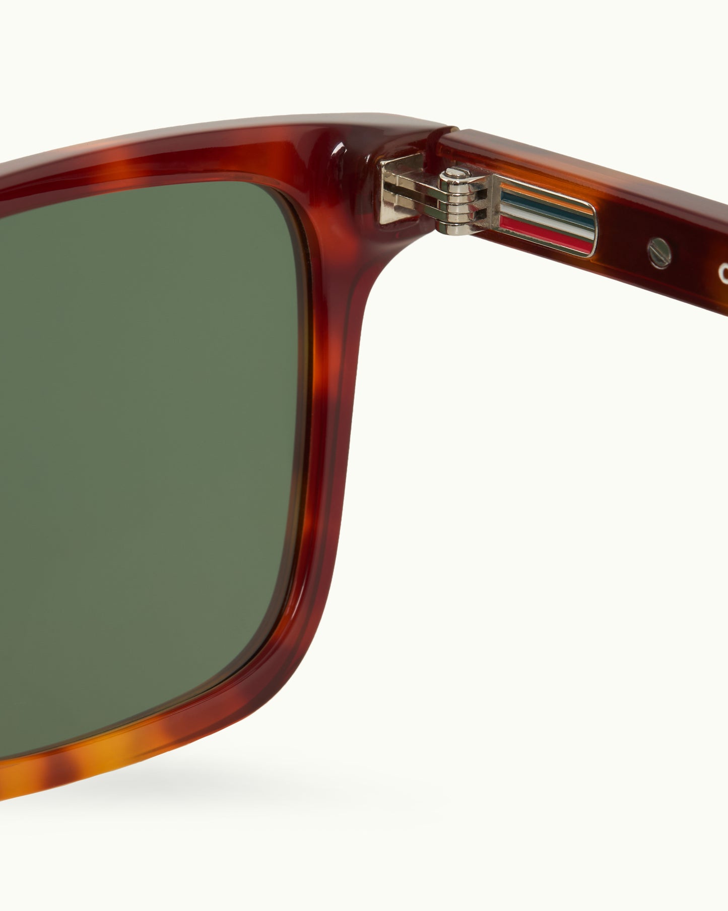 Sunglasses with tortoiseshell frame and green lenses on a white background