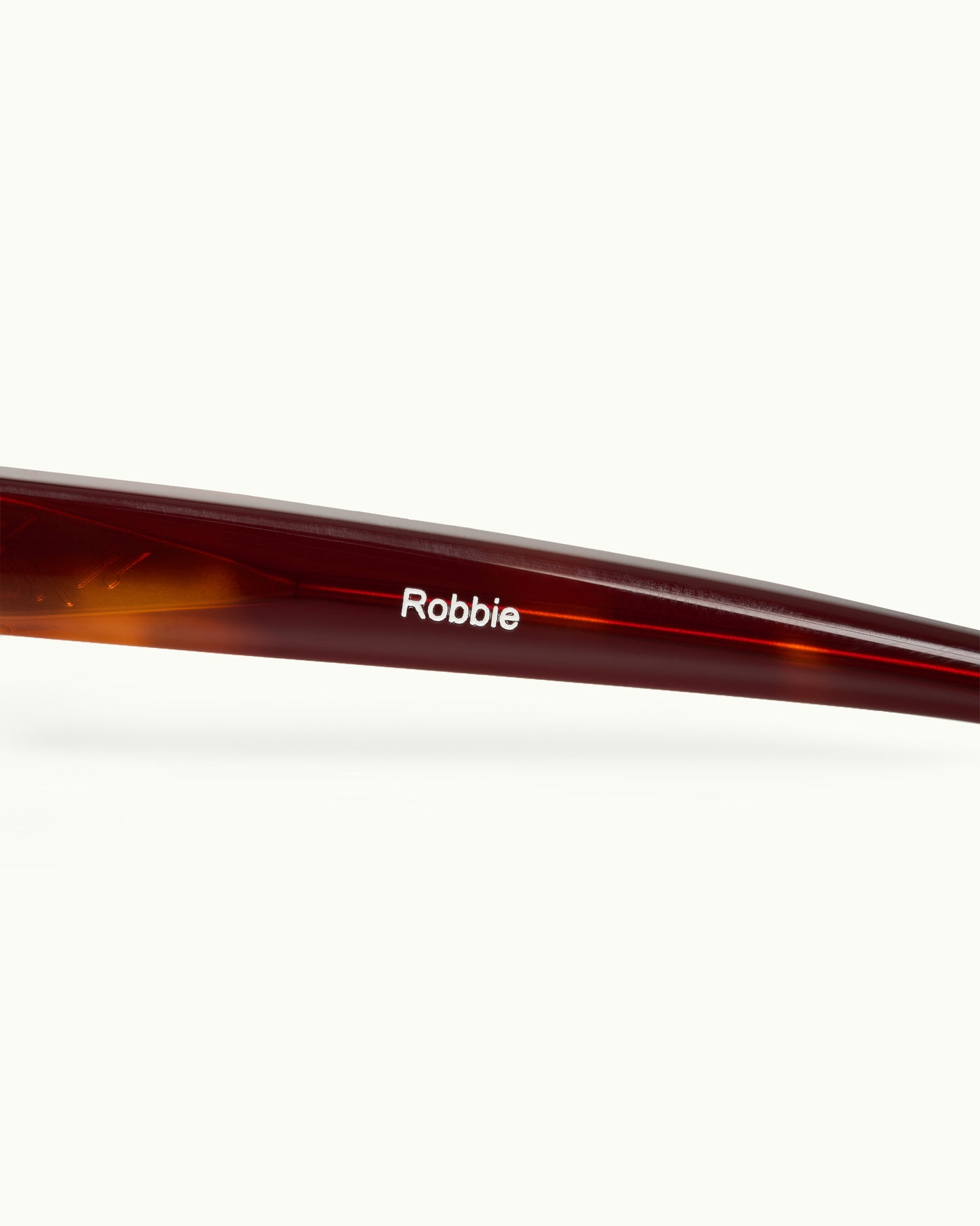 Brown sunglasses with 'Robbie' branding on a white background