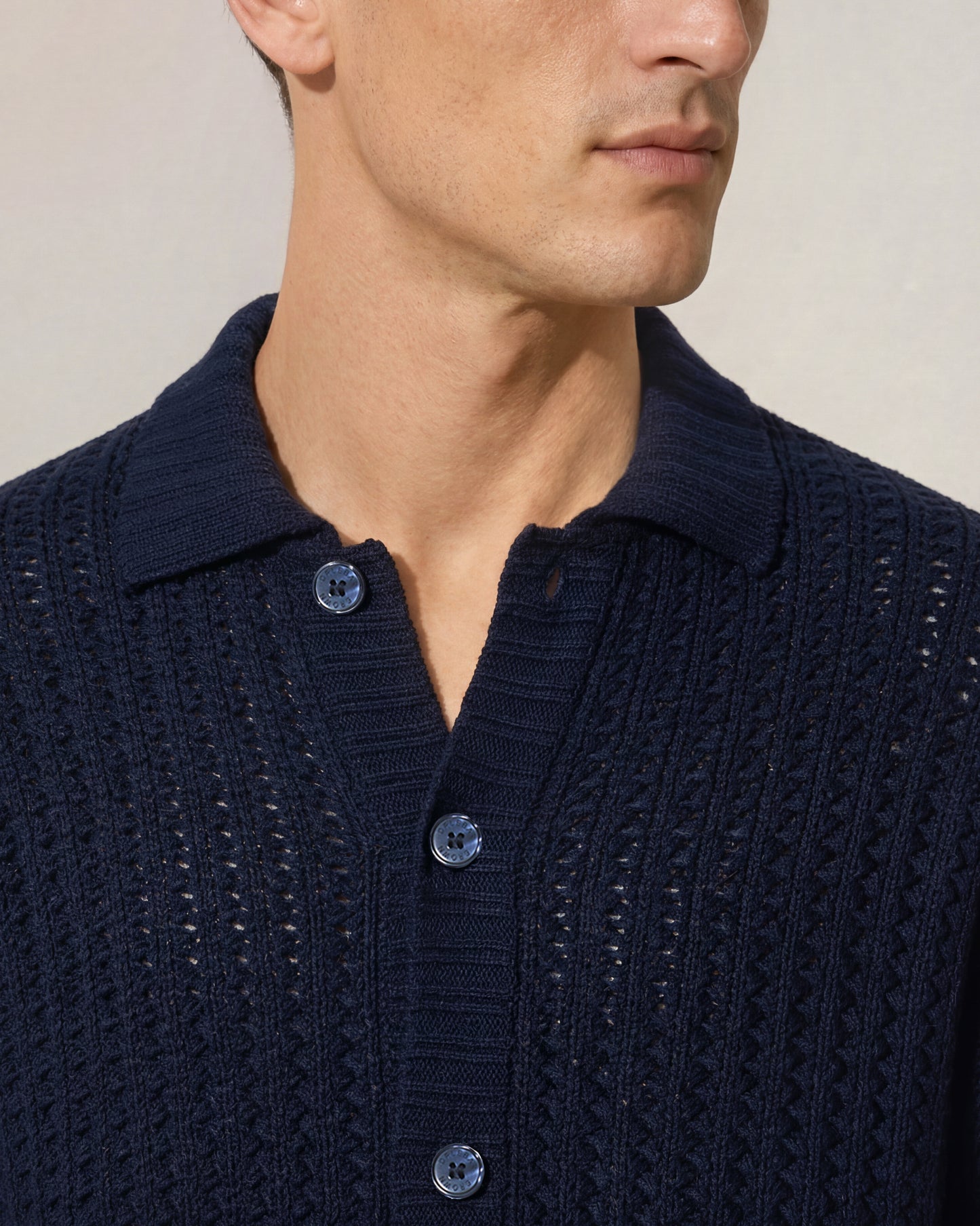 Navy blue textured sweater worn by a person on a neutral background