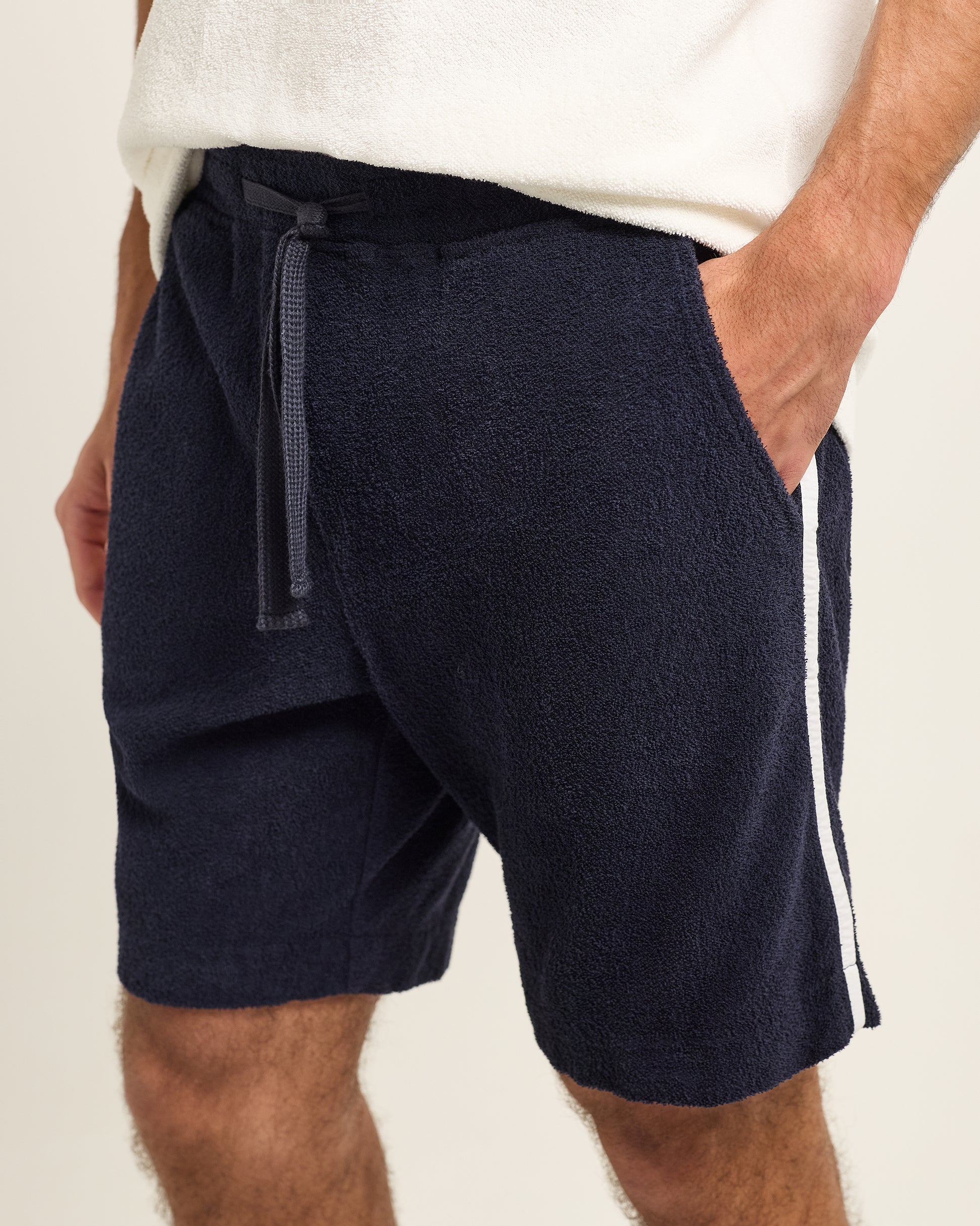 Navy shorts with a white stripe on a beige background