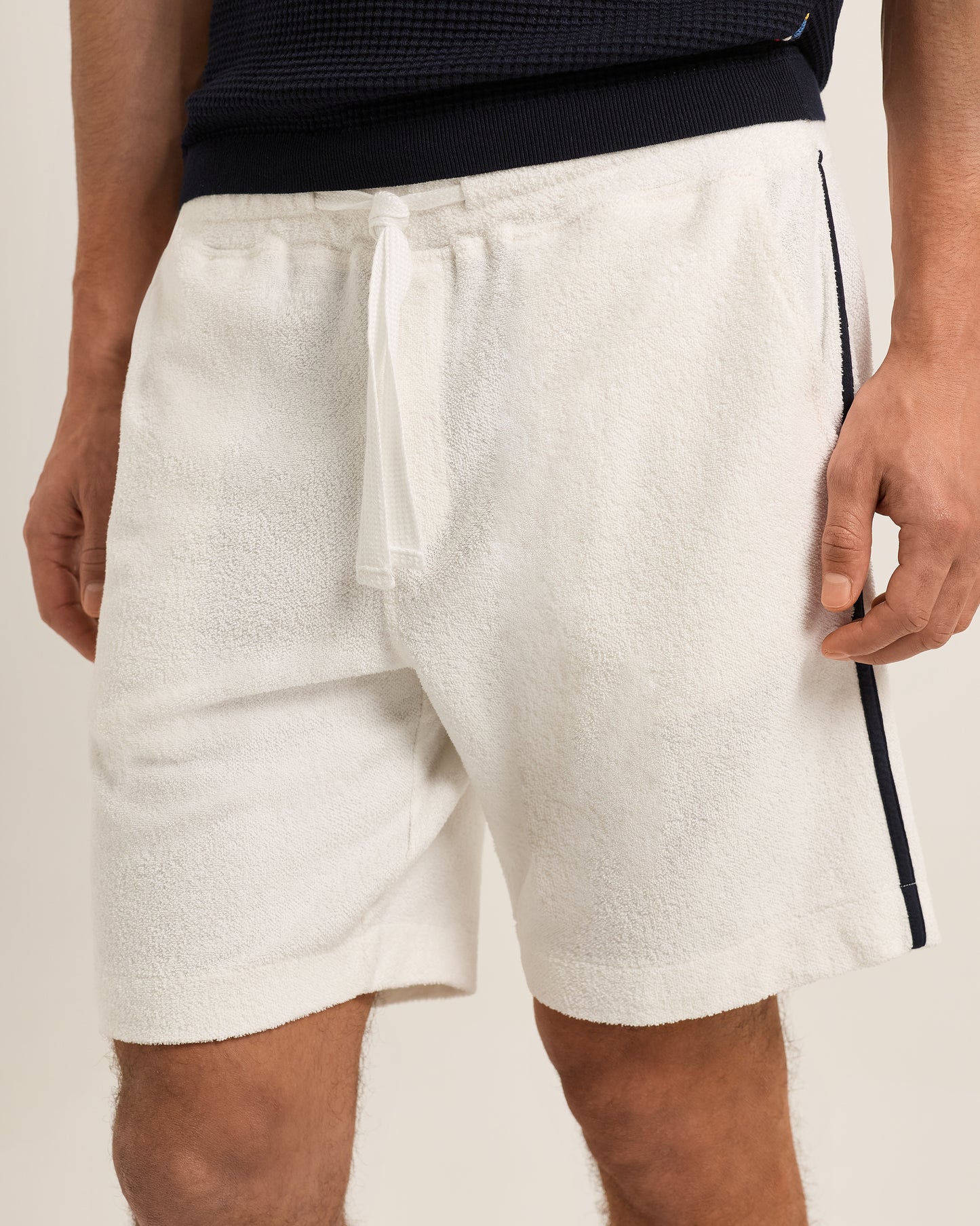 White textured shorts worn by a person on a plain background