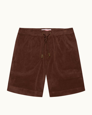 A pair of dark brown shorts with an elastic drawstring waistband, laid flat against a light cream background.