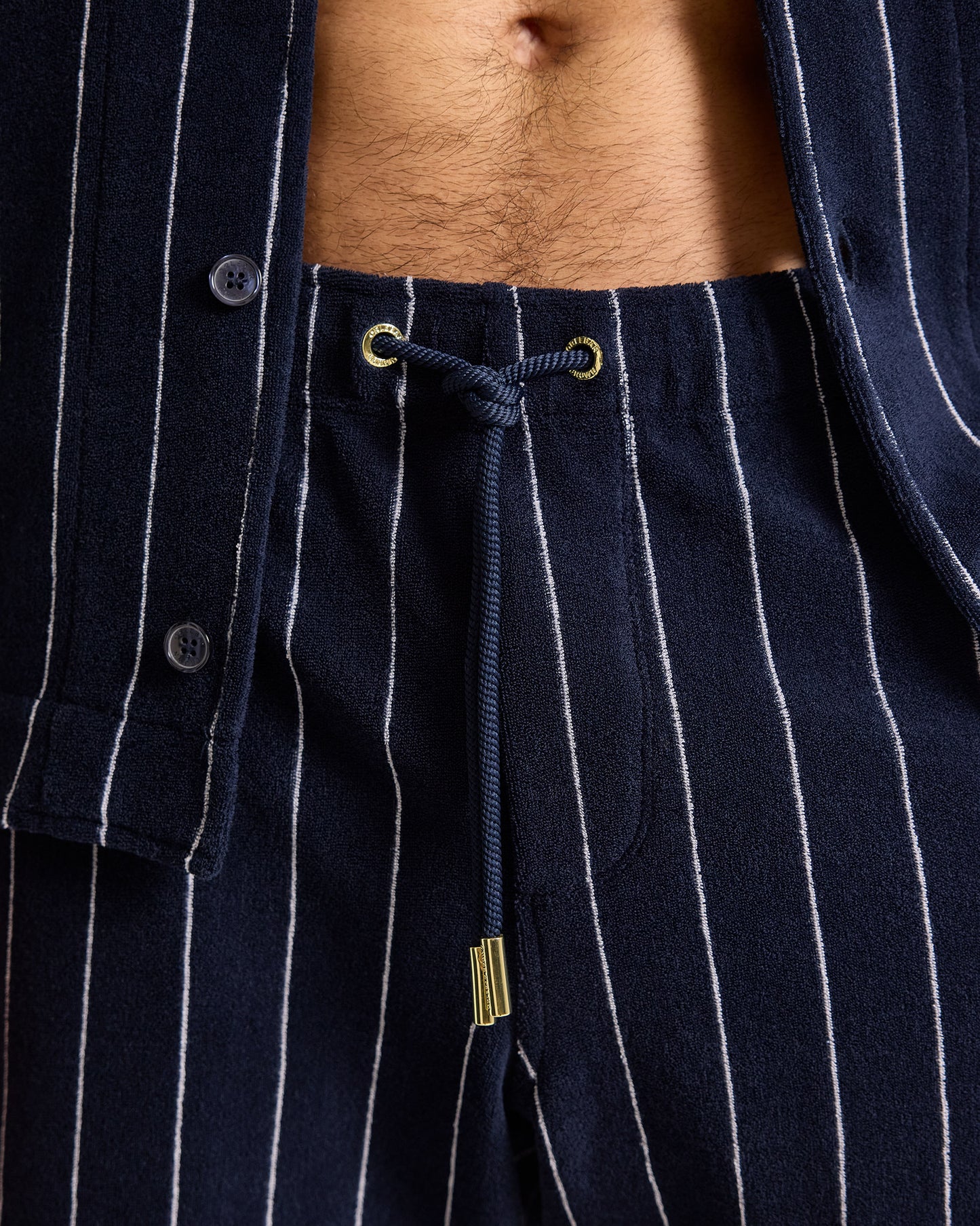 Navy pinstripe shirt with a drawstring detail on a person wearing it.