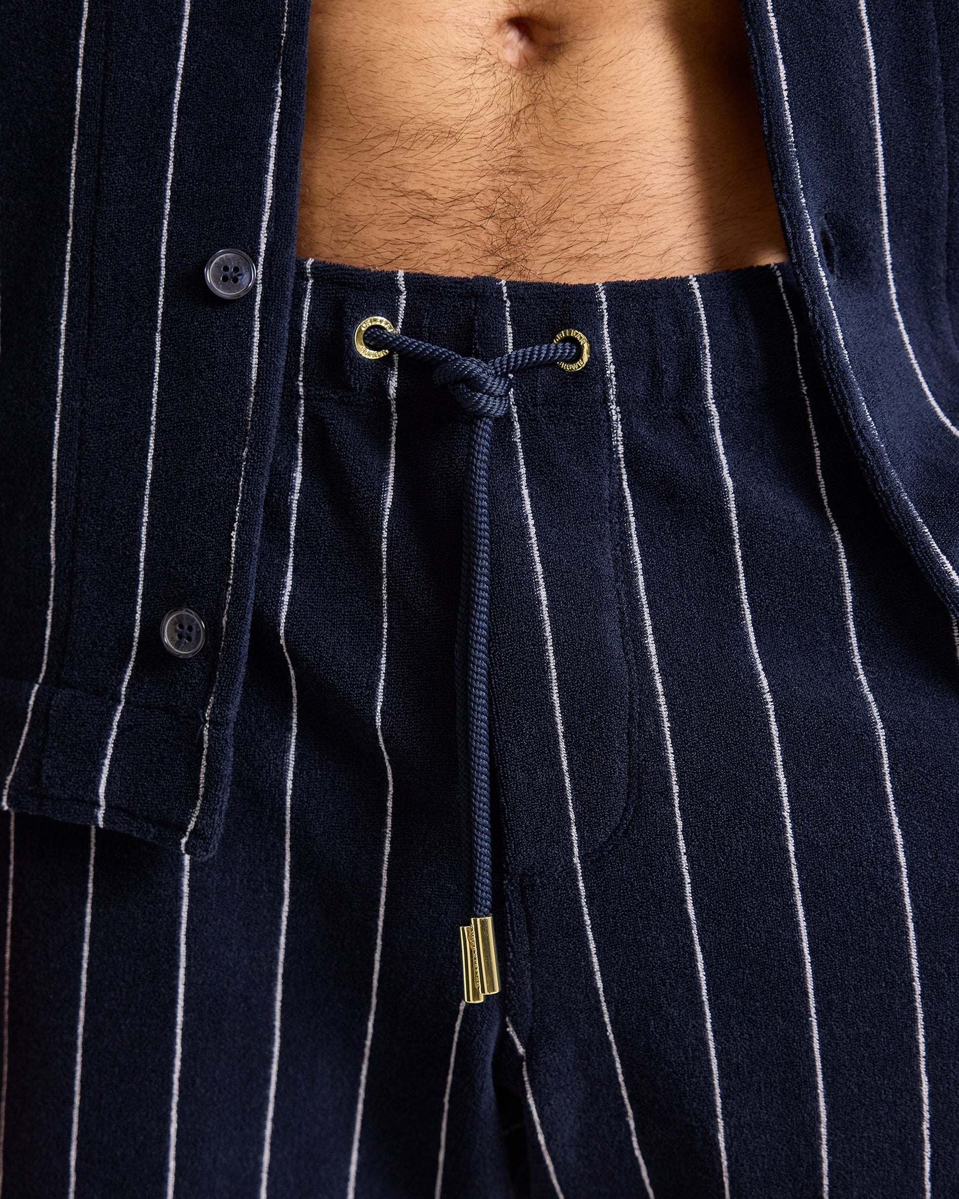 Navy pinstripe shirt with a drawstring detail on a person wearing it.