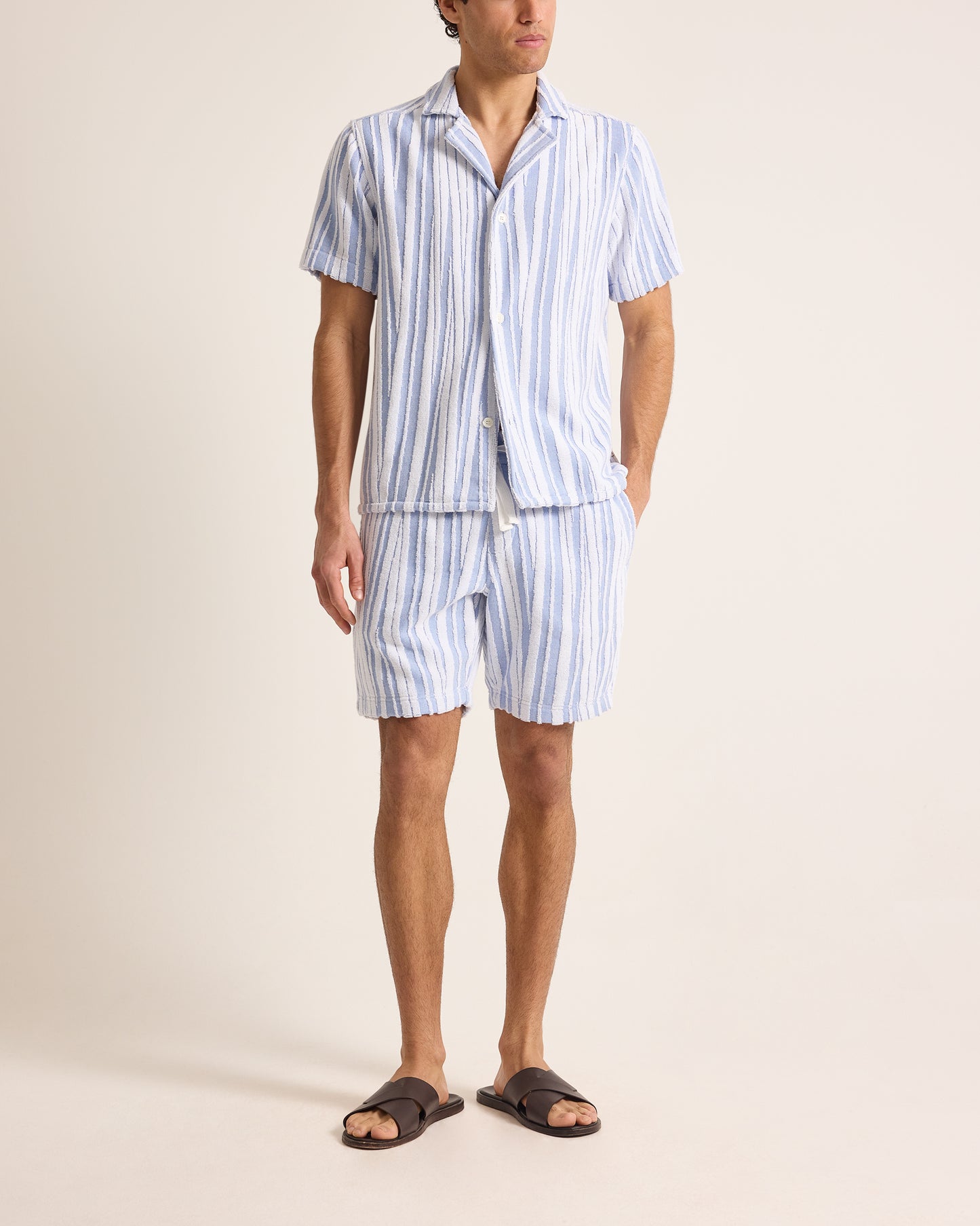 Person wearing a blue and white striped set on a beige background