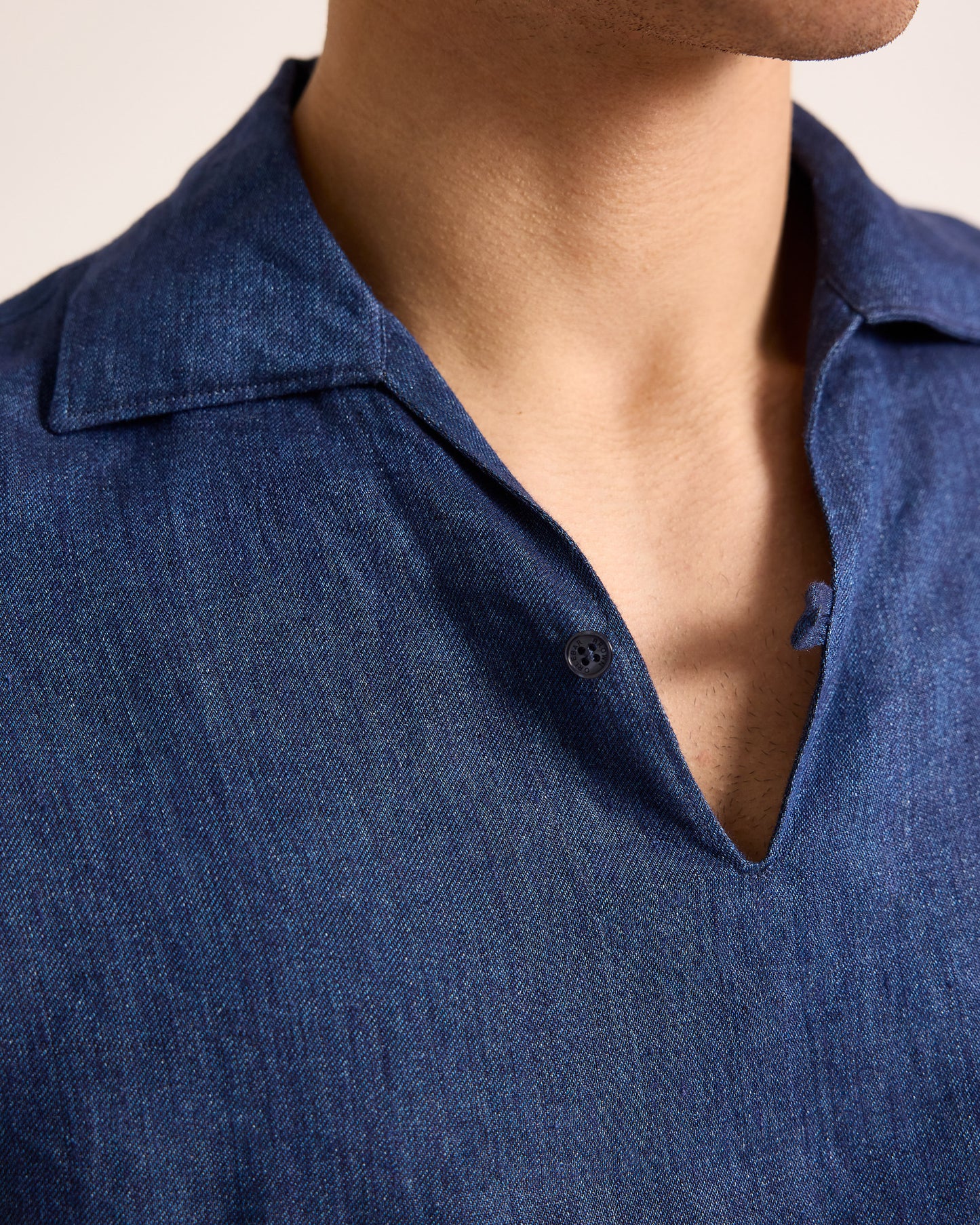 Close-up of a person wearing a blue shirt with a collar.