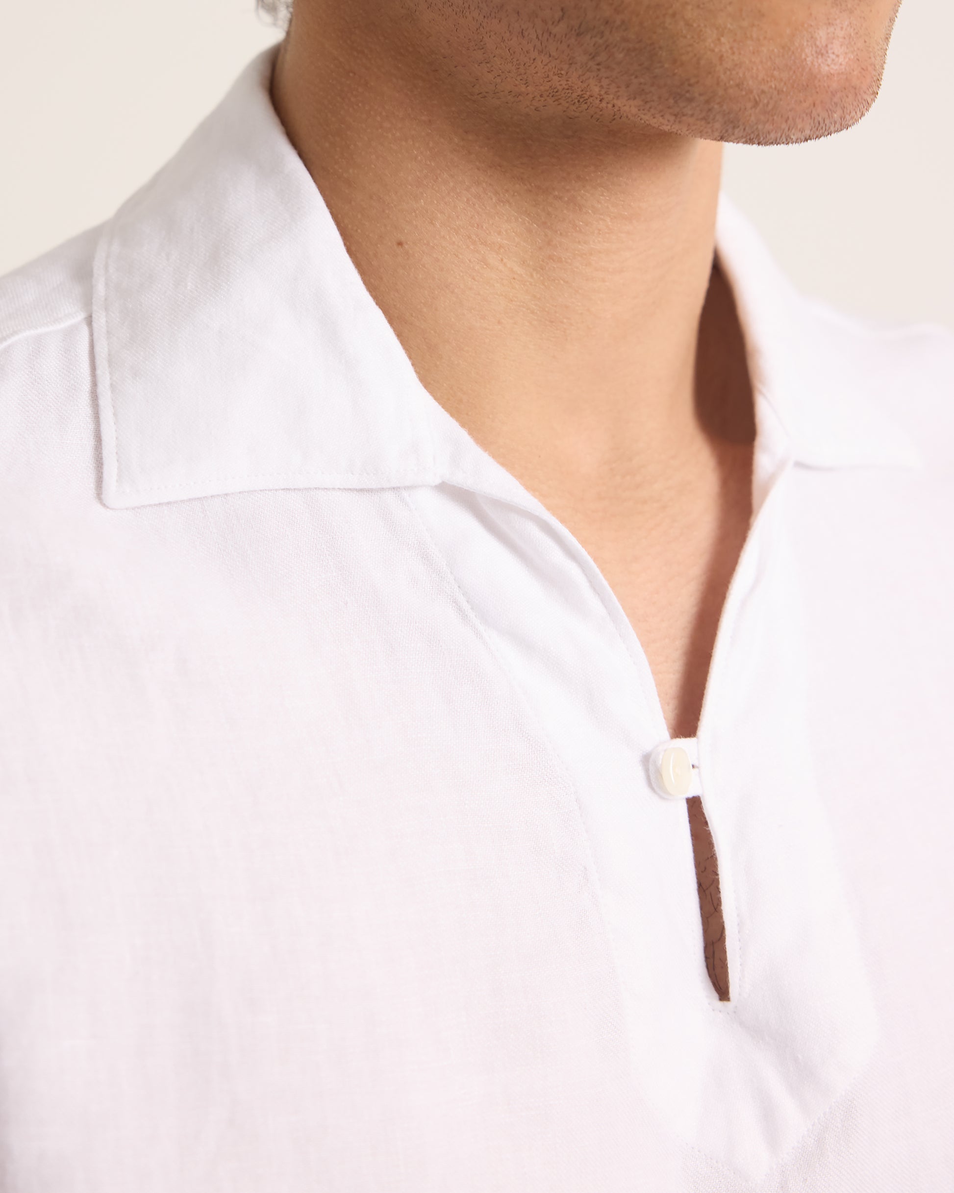Close-up of a person wearing a white shirt with a collar.