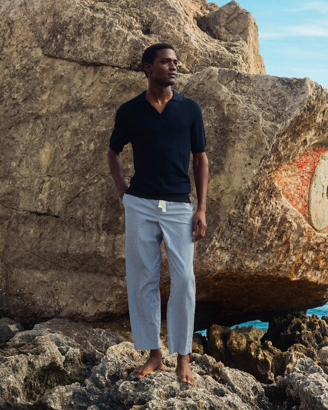 Man standing on rocky terrain with large rock formations in the background