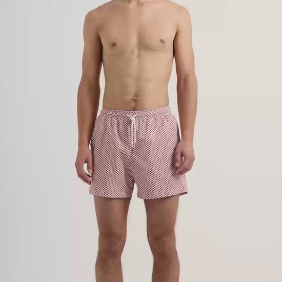 Man wearing red patterened swim shorts with drawstring waist