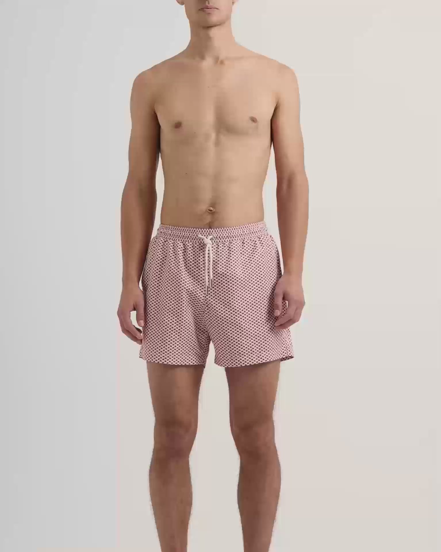 Man wearing red patterened swim shorts with drawstring waist