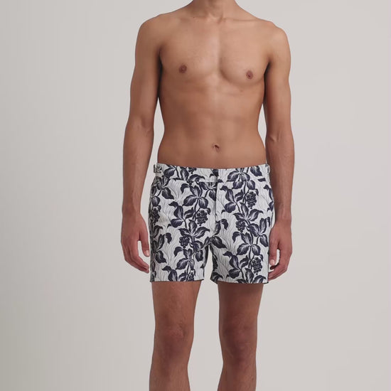 Man wearing white and navy floral print shirt on a plain background