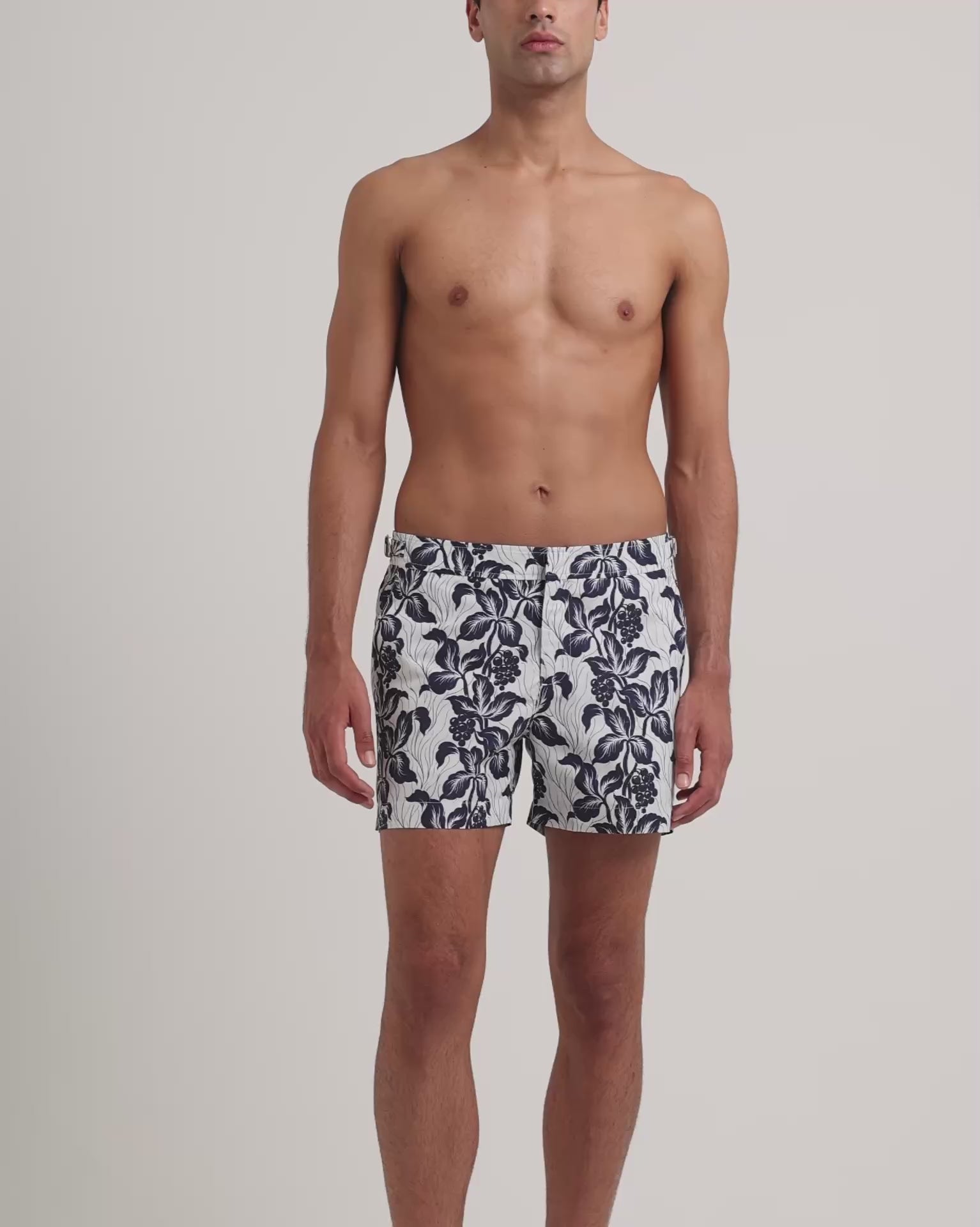 Man wearing white and navy floral print shirt on a plain background