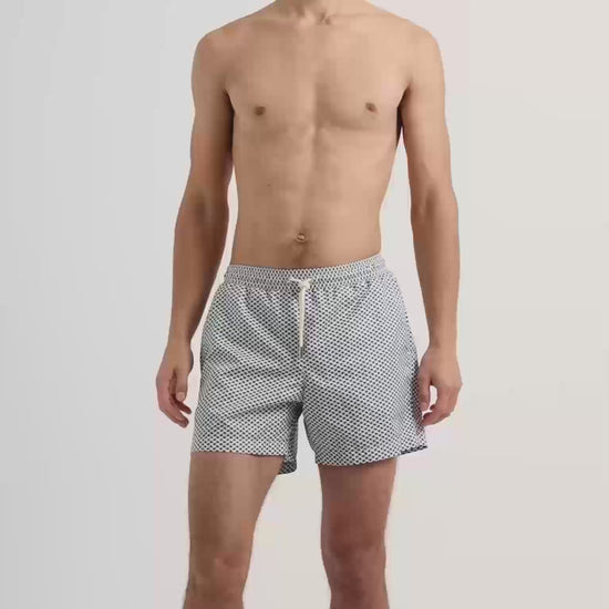 Man wearing blue patterned swim shorts with drawcord waist