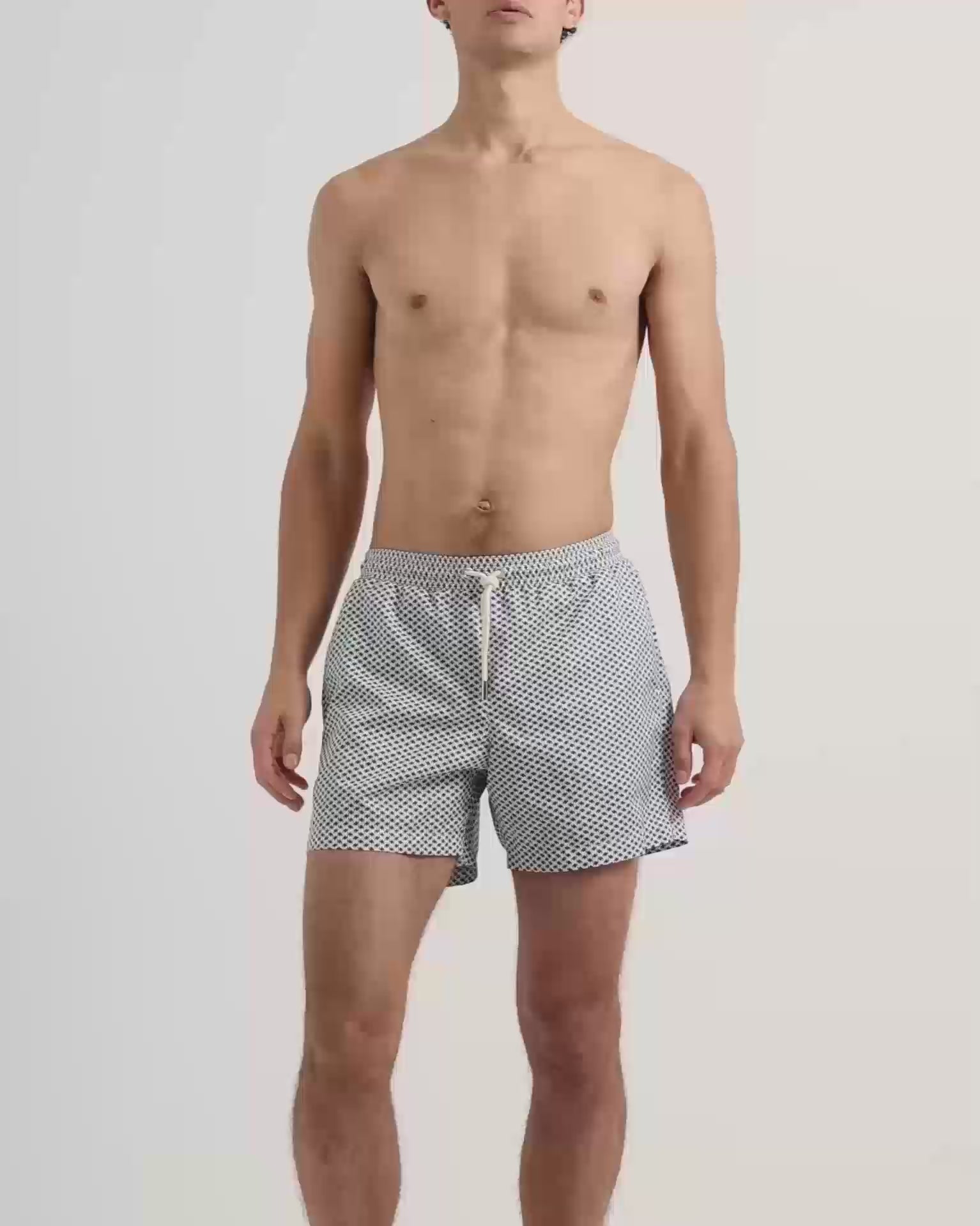 Man wearing blue patterned swim shorts with drawcord waist